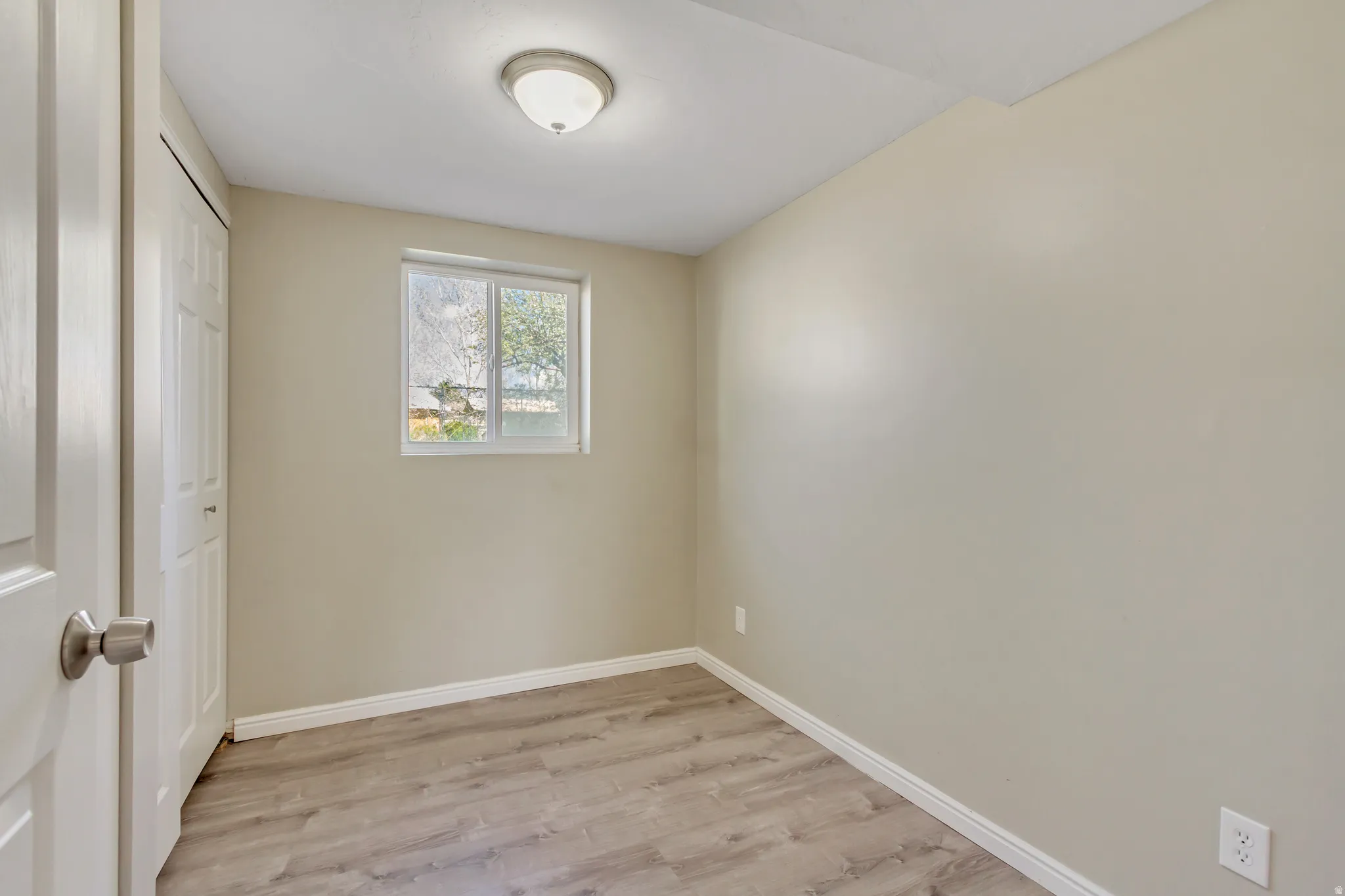 Unfurnished bedroom with light wood-style floors and a closet