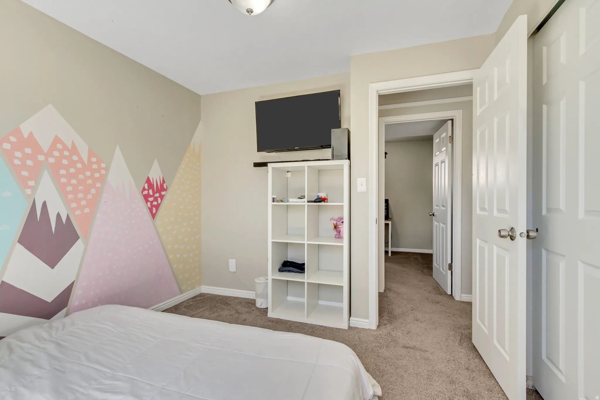 Bedroom featuring light carpet and baseboards