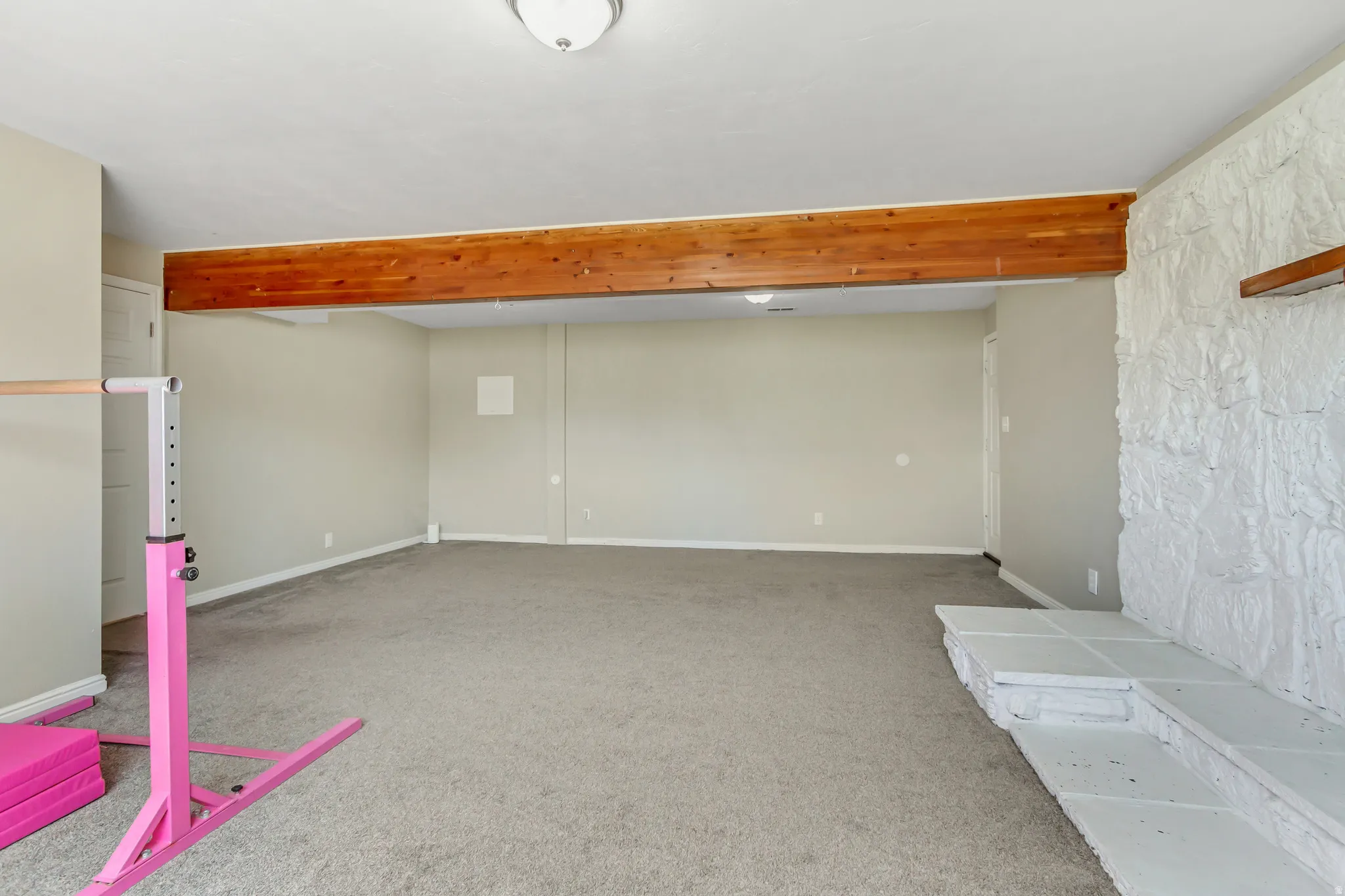 Basement featuring light colored carpet and baseboards