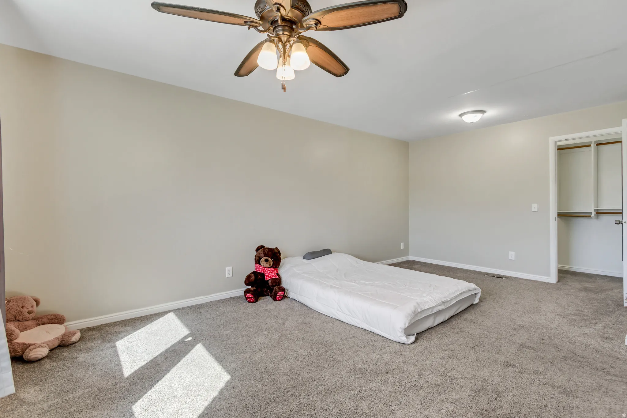 Carpeted bedroom featuring baseboards and ceiling fan