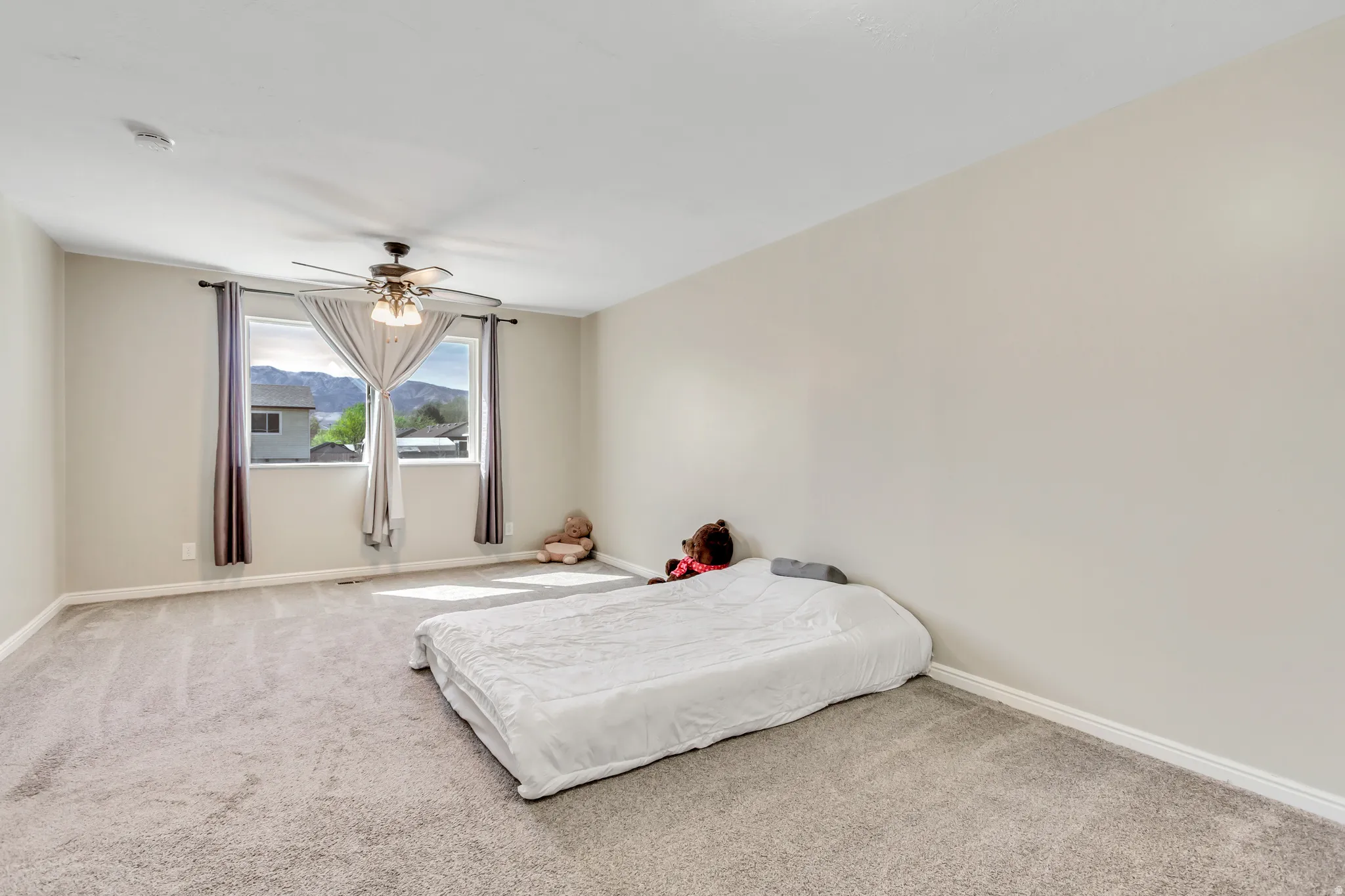 Carpeted bedroom featuring a ceiling fan and a mountain view
