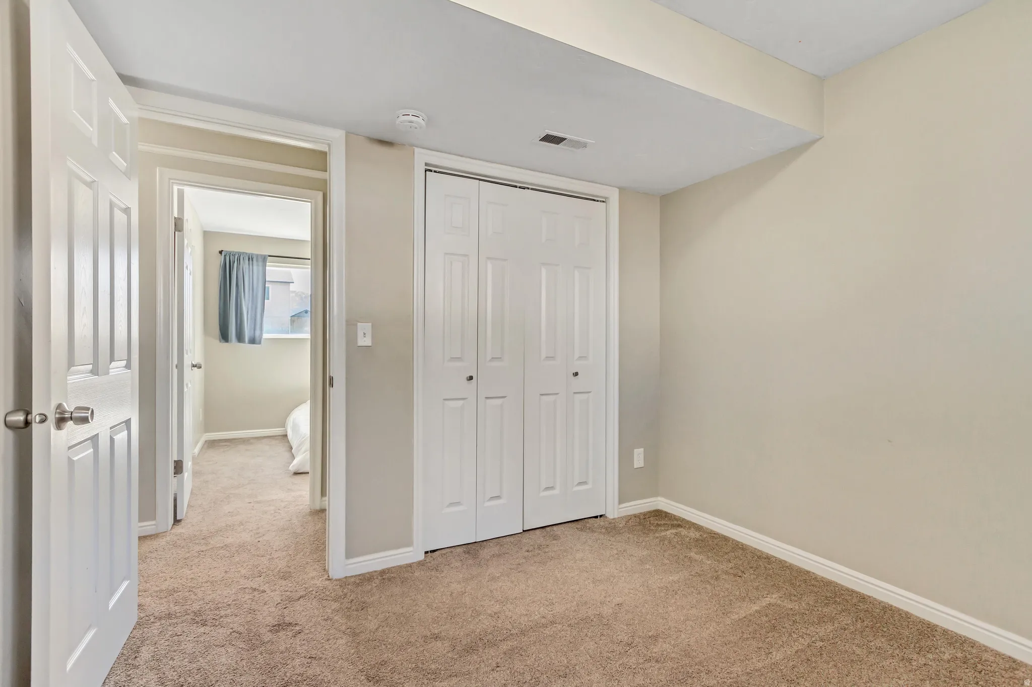 Unfurnished bedroom featuring light carpet and a closet