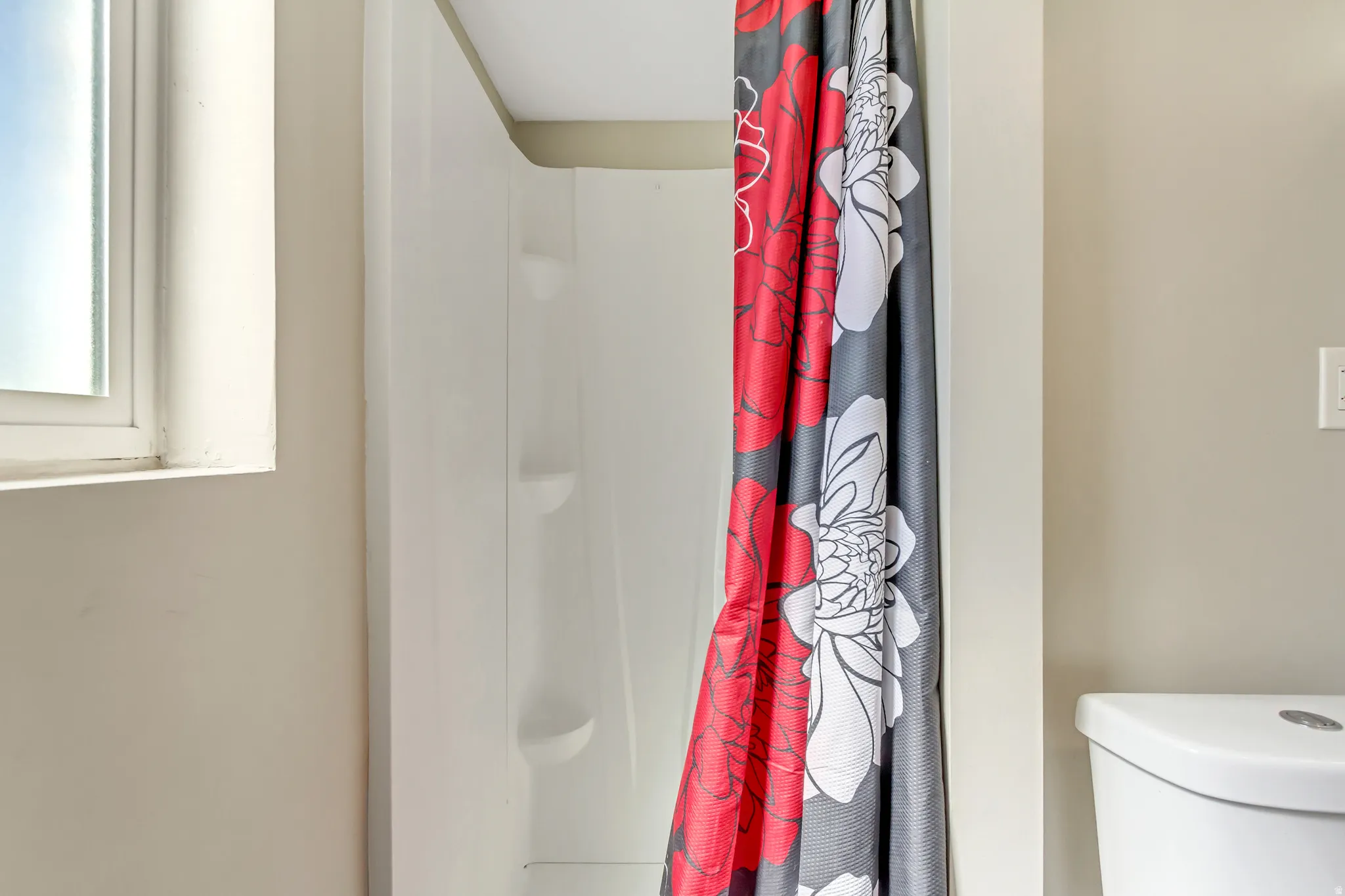 Full bath featuring a shower stall and toilet