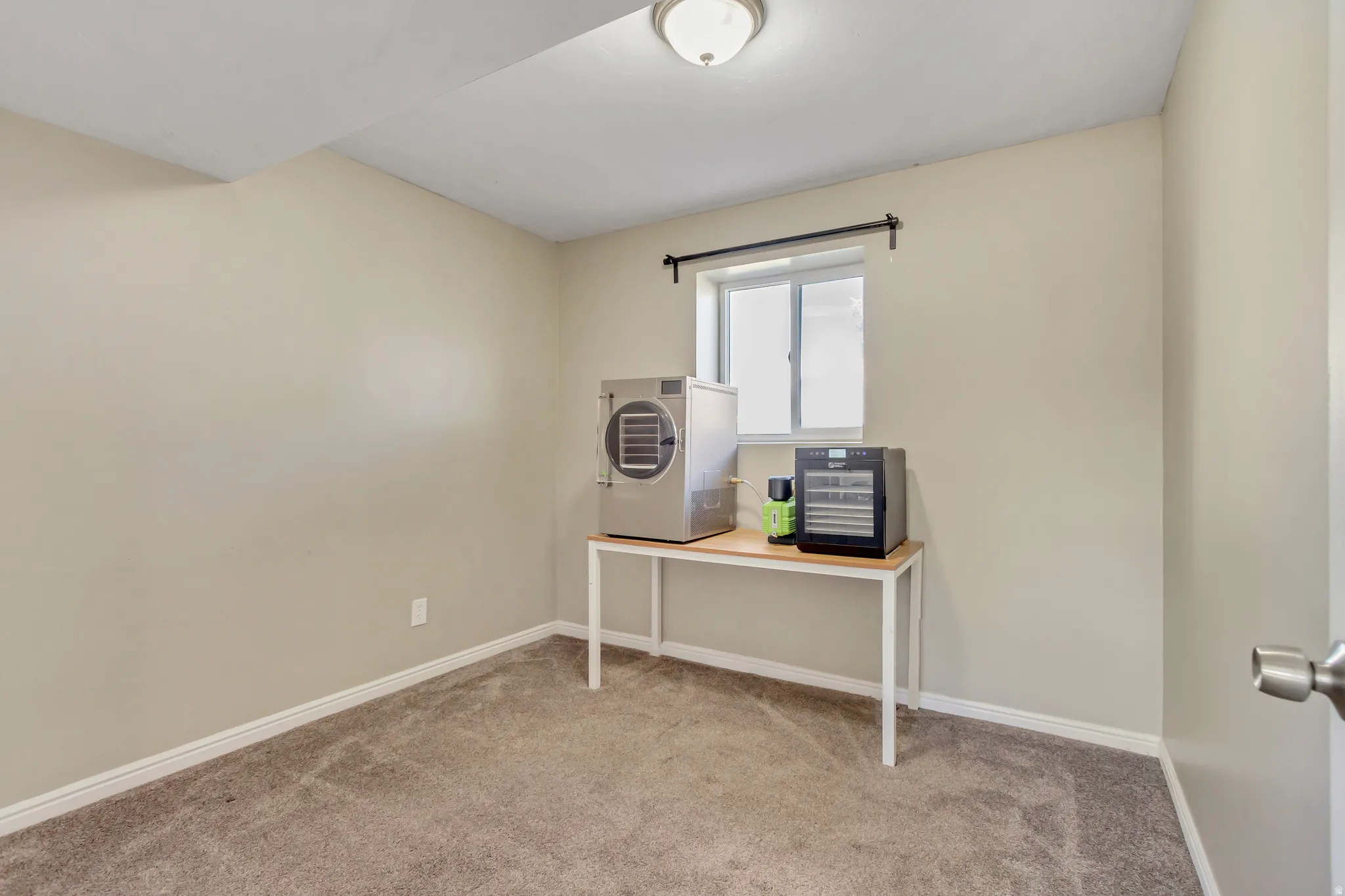 Office area with baseboards and light carpet