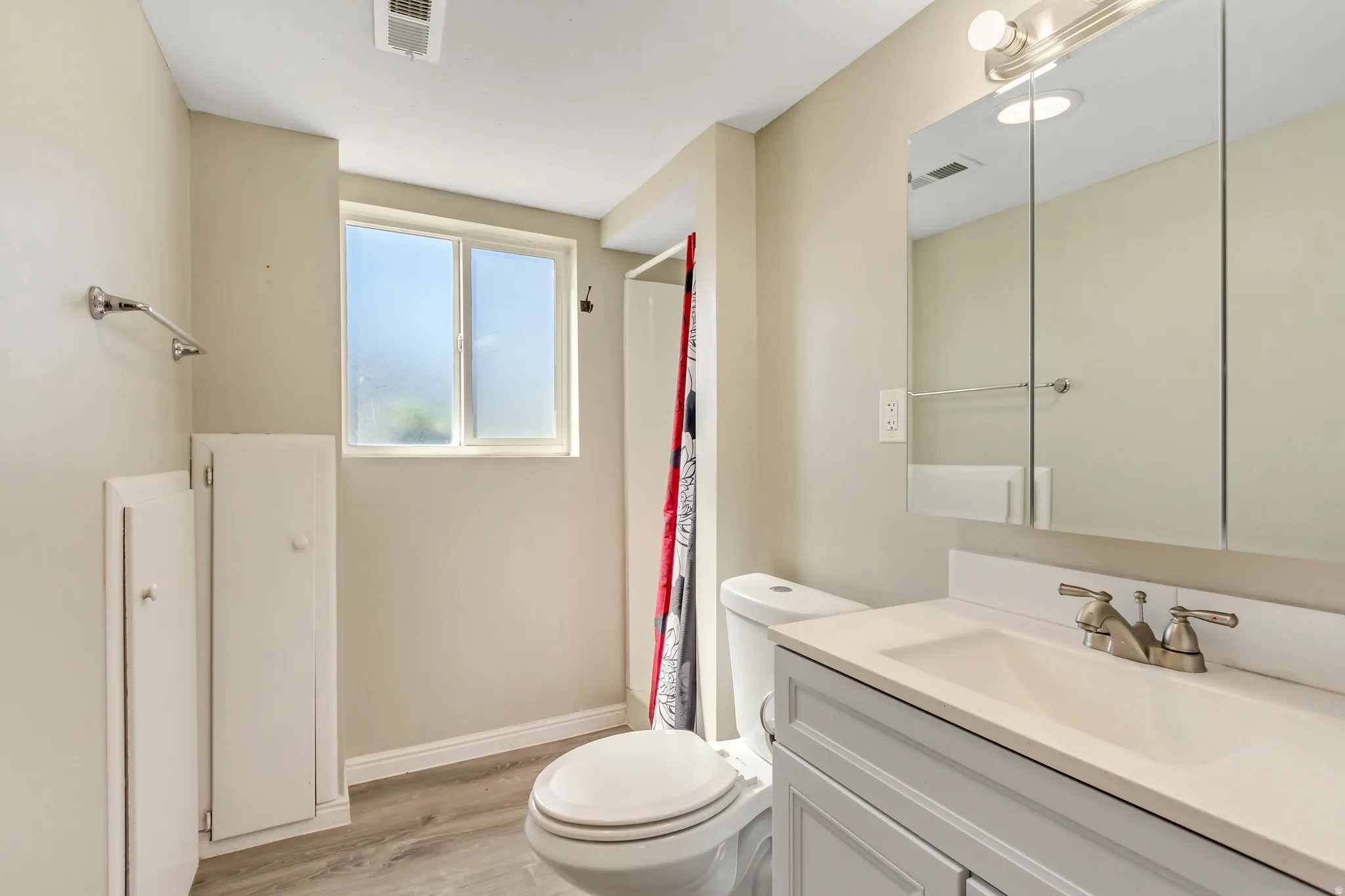 Full bath featuring vanity, light wood finished floors, and a shower with curtain