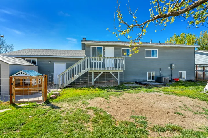 Back of property featuring a patio area, a deck, a yard, and a shingled roof