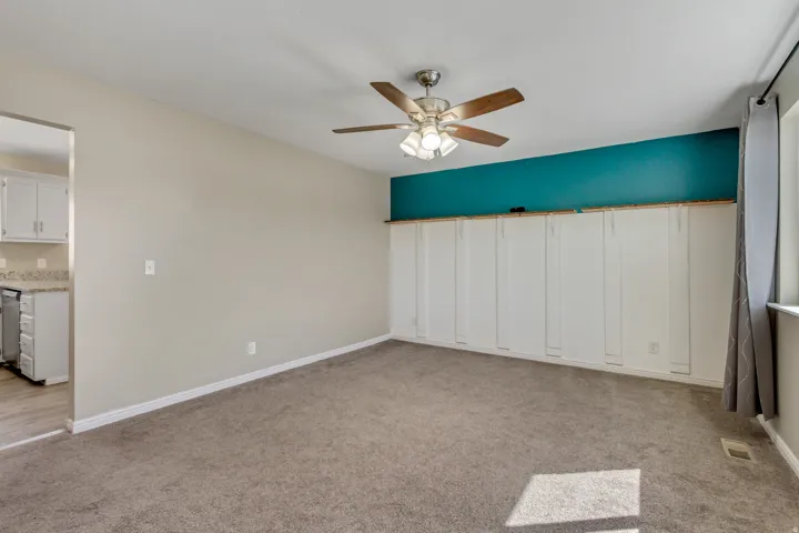 Unfurnished room with light colored carpet and ceiling fan