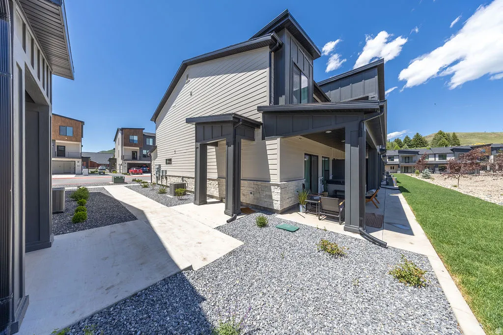 Contemporary exterior featuring mixed-material siding, a covered patio, and a gravel landscape