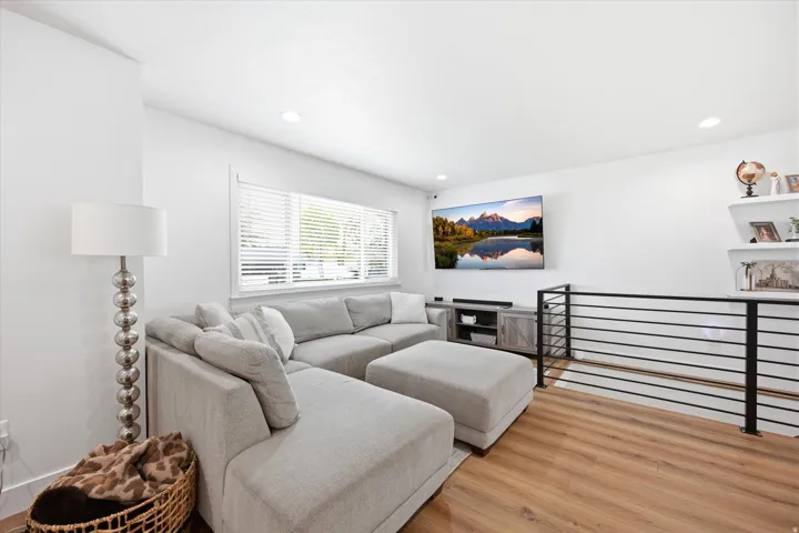 Living room with light wood-type flooring and recessed lighting