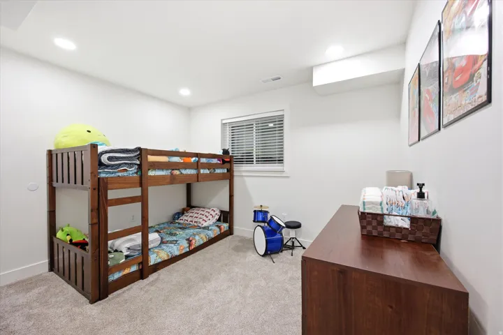 Bedroom with light colored carpet and recessed lighting