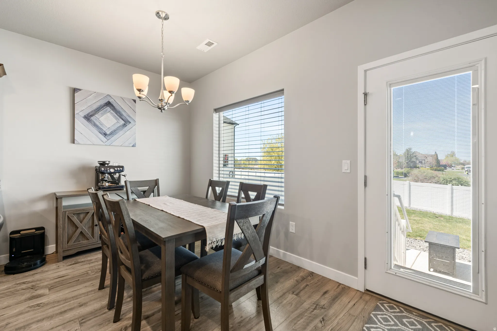 Dining area featuring LVP floors and suspended lighting