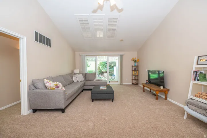 Large living room opens to private deck and yard space overlooking the golf course. New carpet!