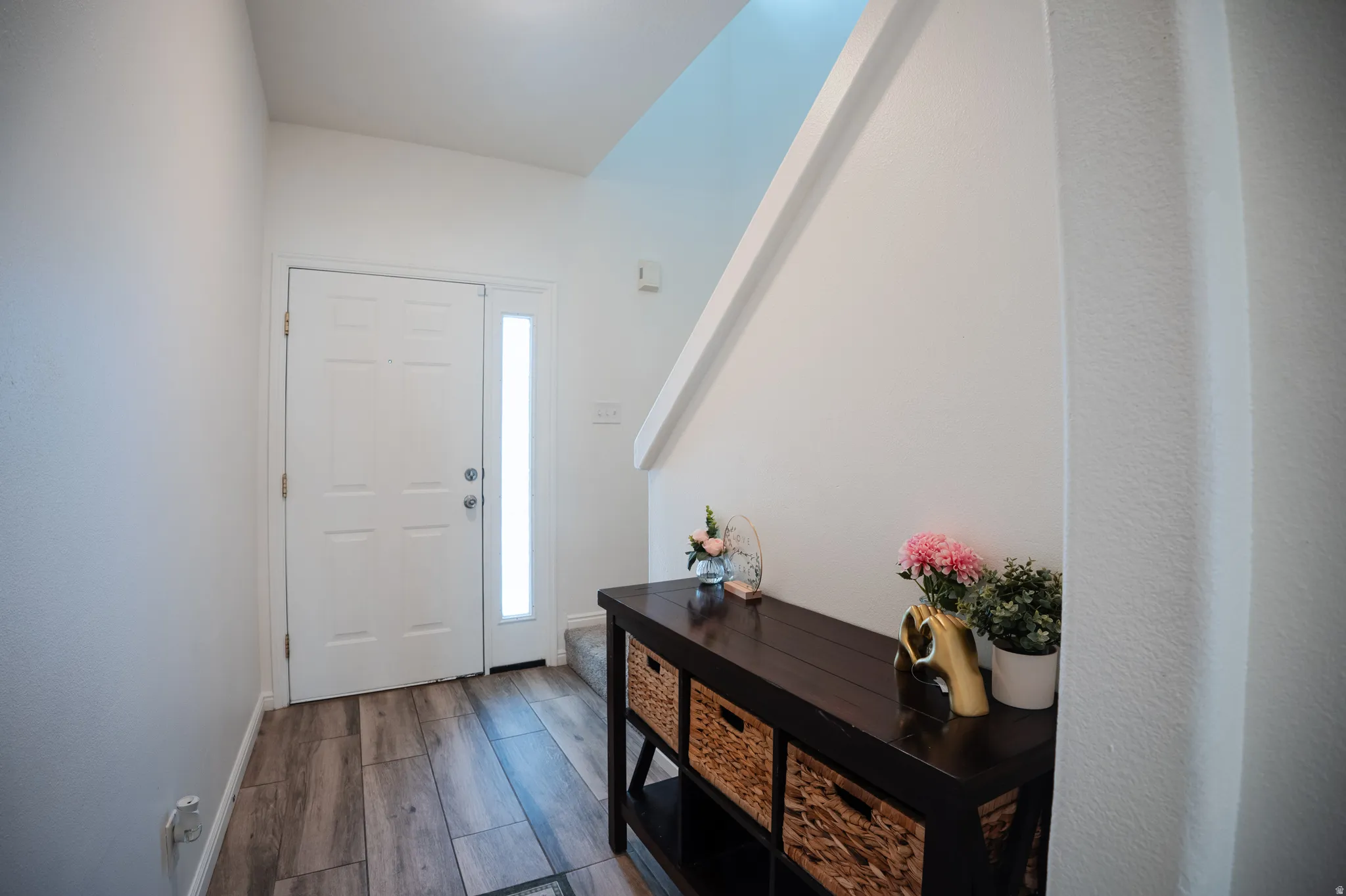 Entrance foyer with dark wood-type flooring and baseboards