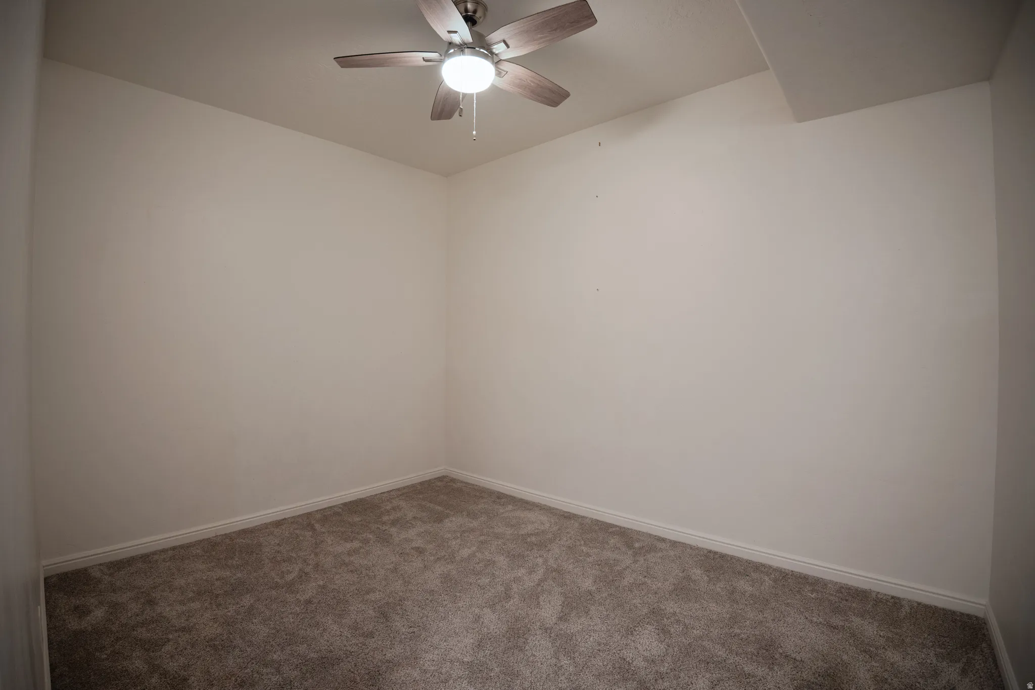 Spare room featuring carpet floors and ceiling fan