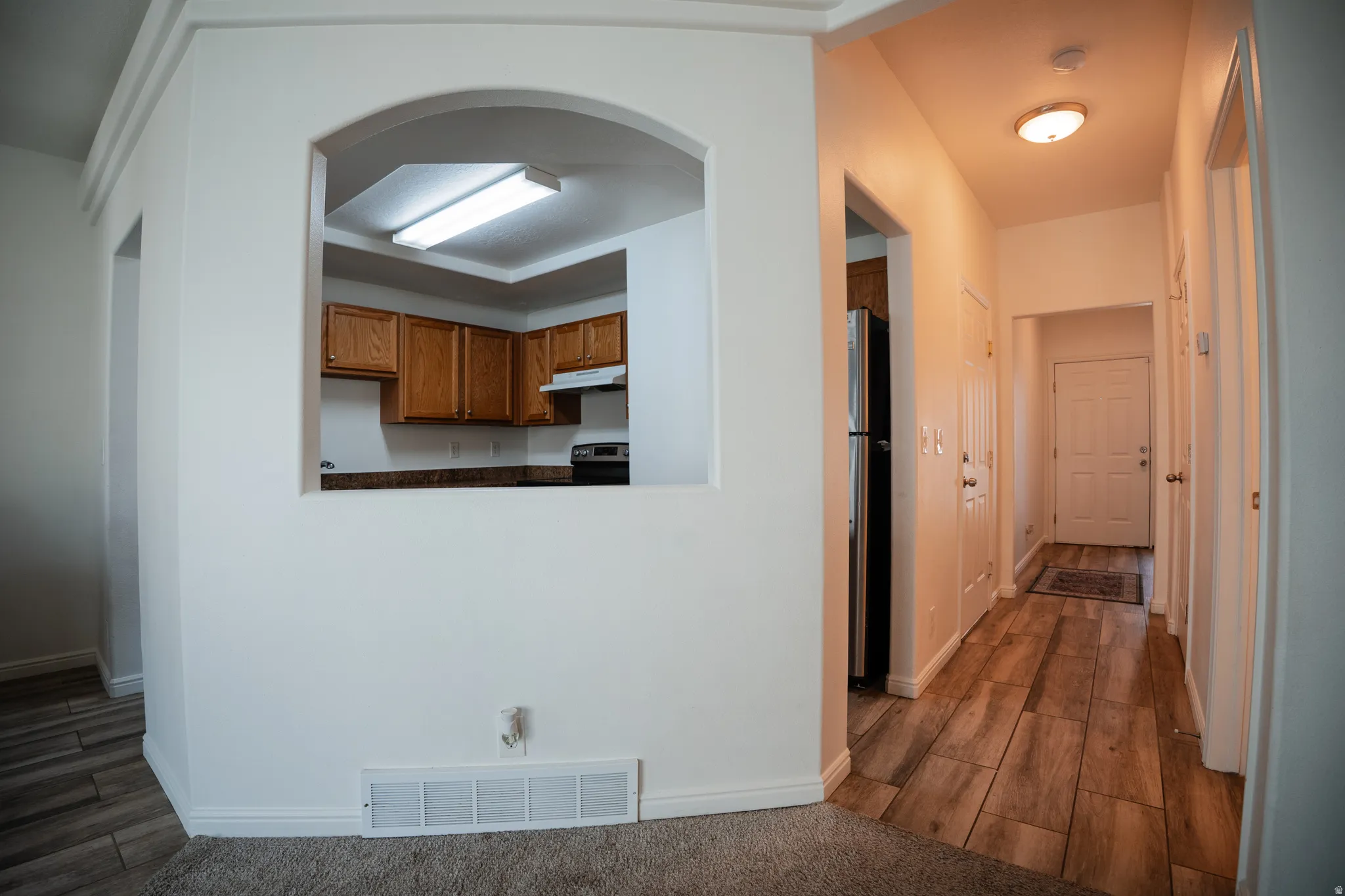 Corridor featuring dark wood-style flooring and arched walkways