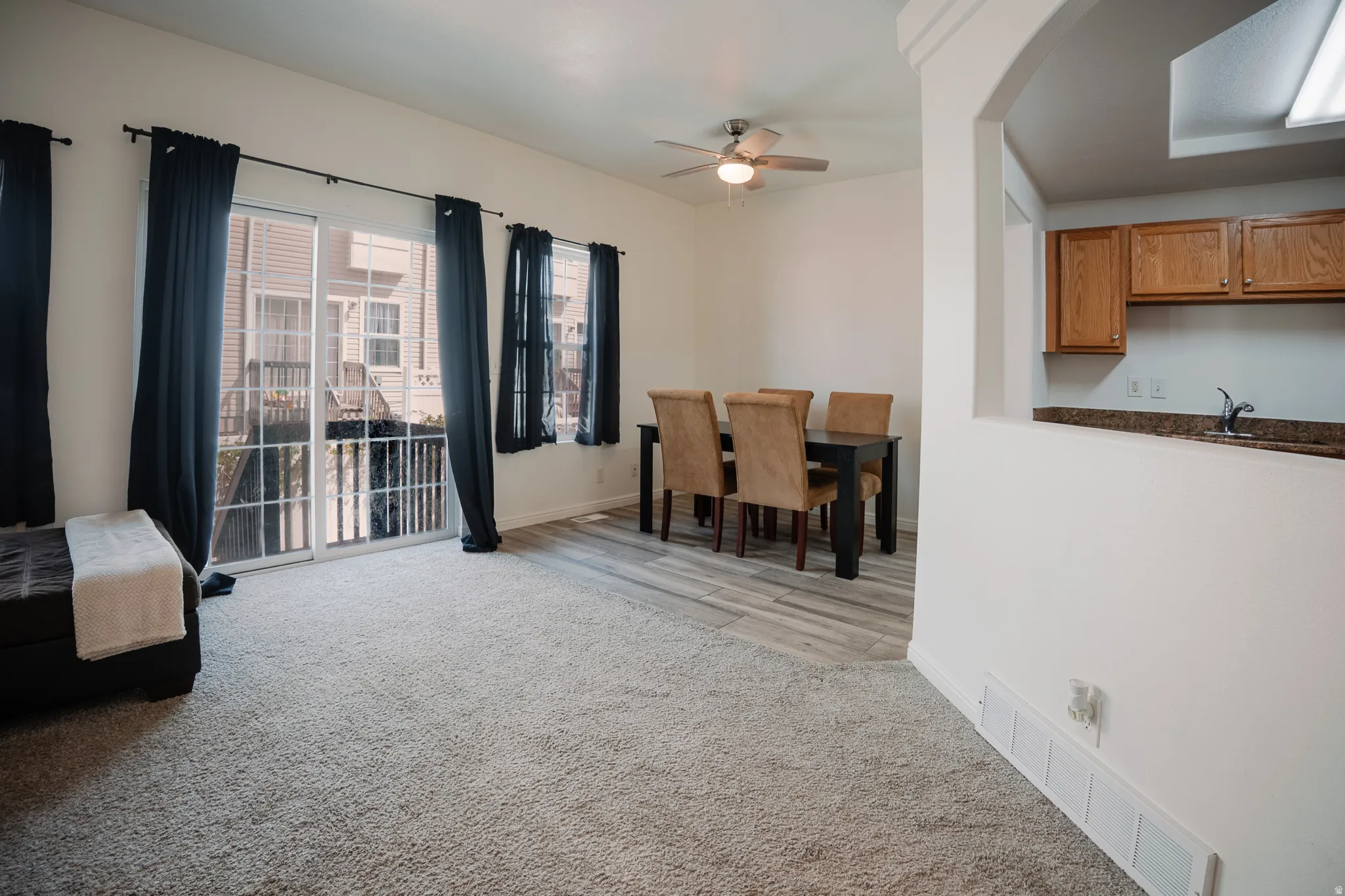 Dining area with ceiling fan and light carpet