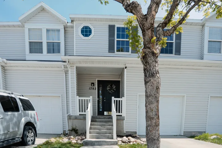 Traditional home featuring covered porch, a garage, and concrete driveway