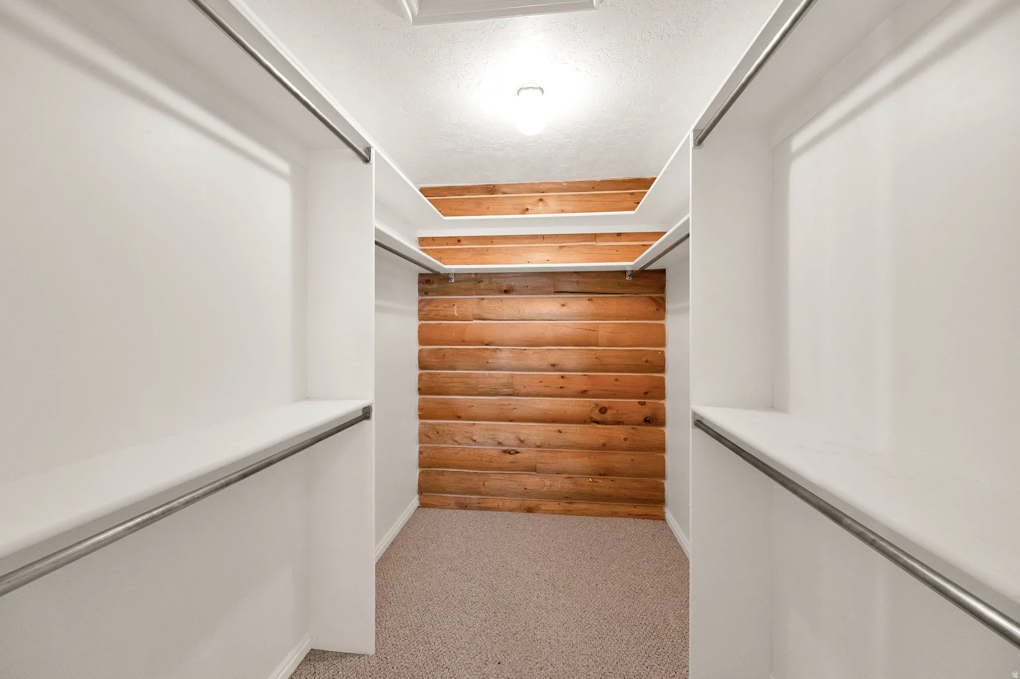 Walk in closet featuring light colored carpet