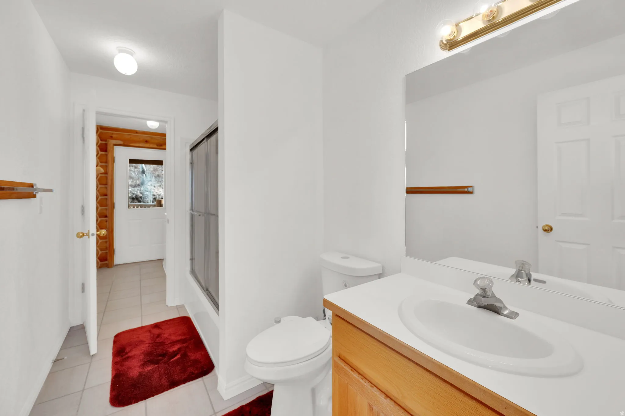 Full bathroom with a shower stall, vanity, and light tile patterned floors