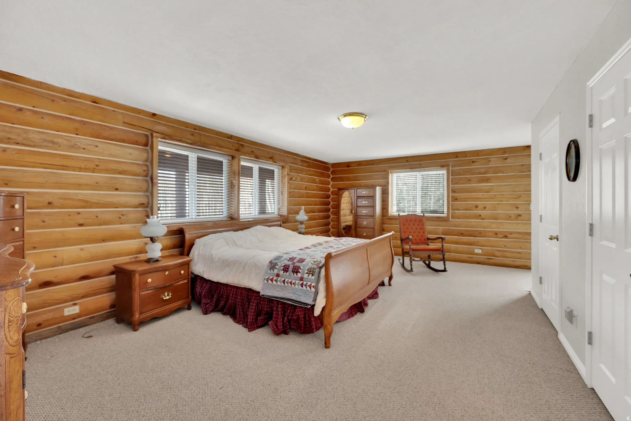 Bedroom with log walls and light colored carpet