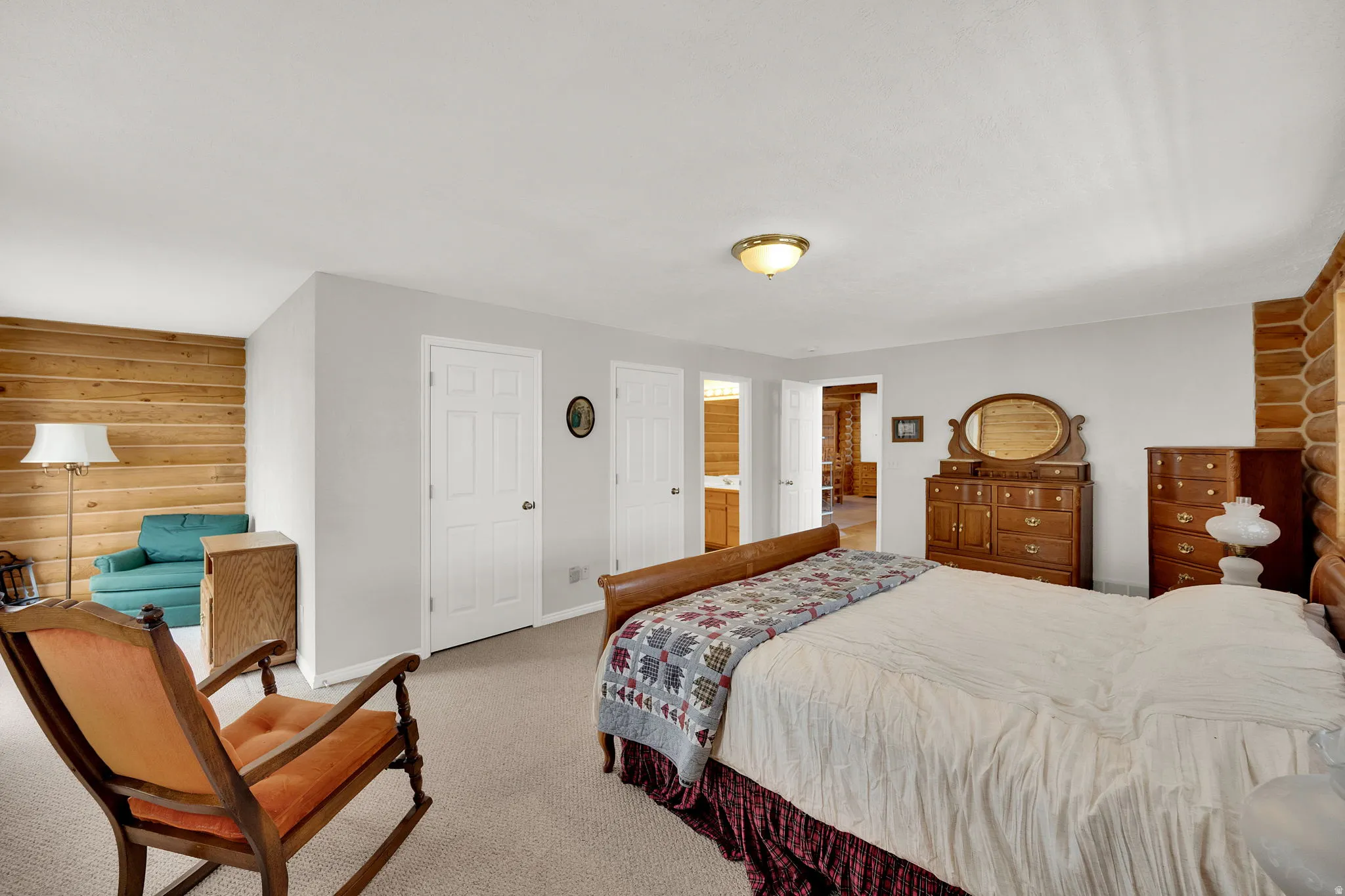 Bedroom featuring log walls, light colored carpet, and a closet