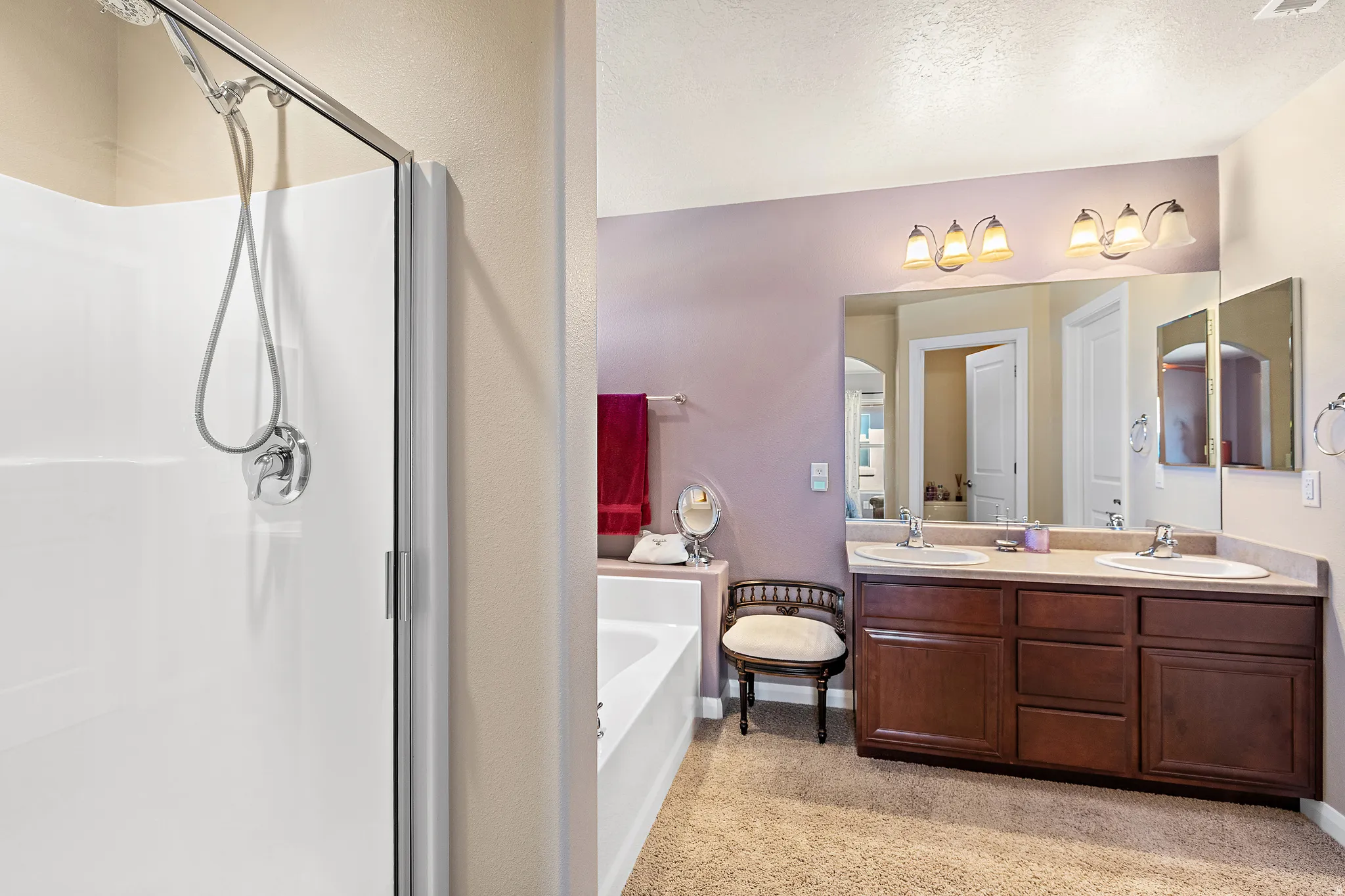 Bathroom with double vanity, a garden tub, a stall shower, and a textured ceiling