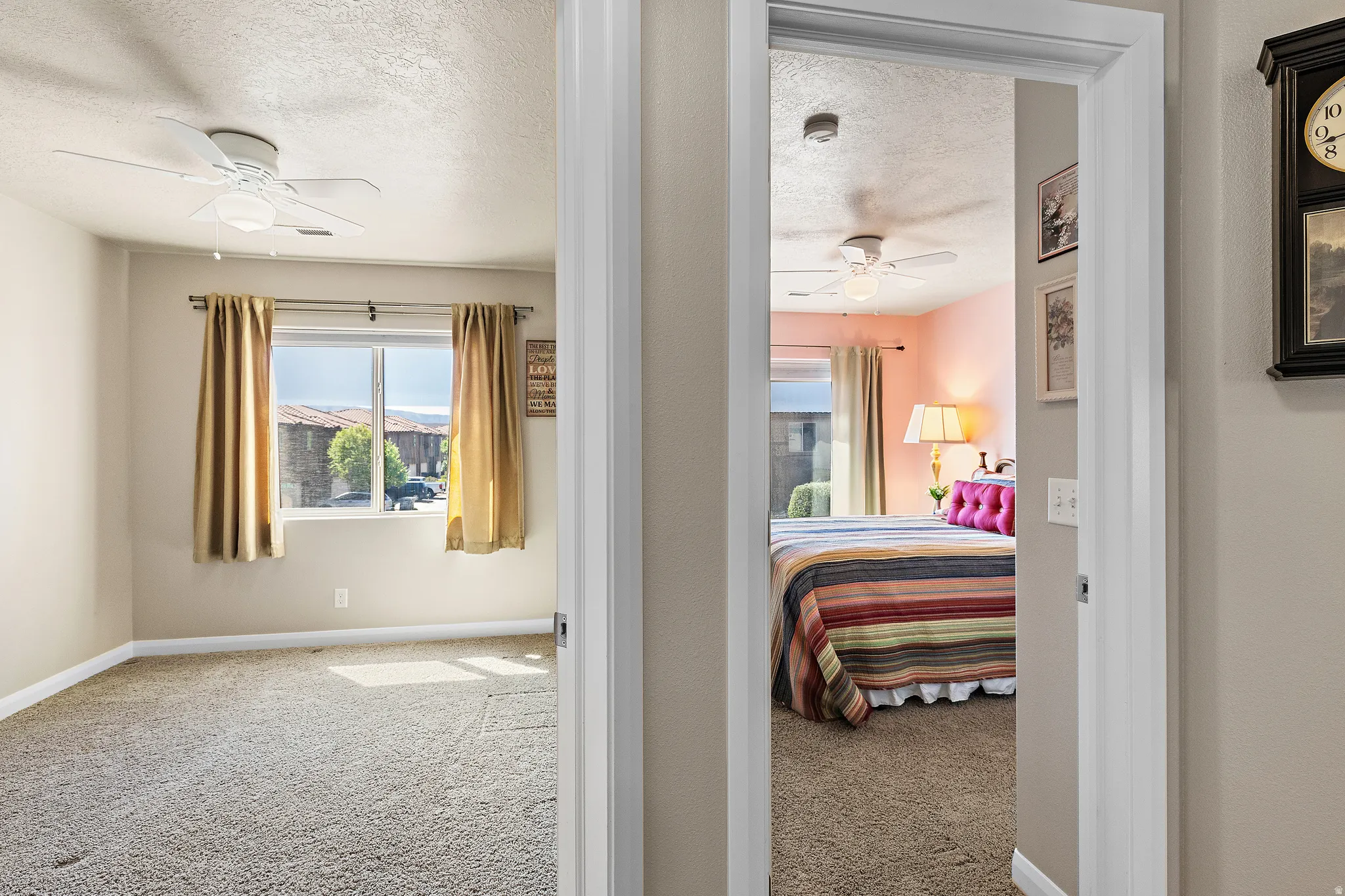 Bedroom featuring light colored carpet, a ceiling fan, and a textured ceiling