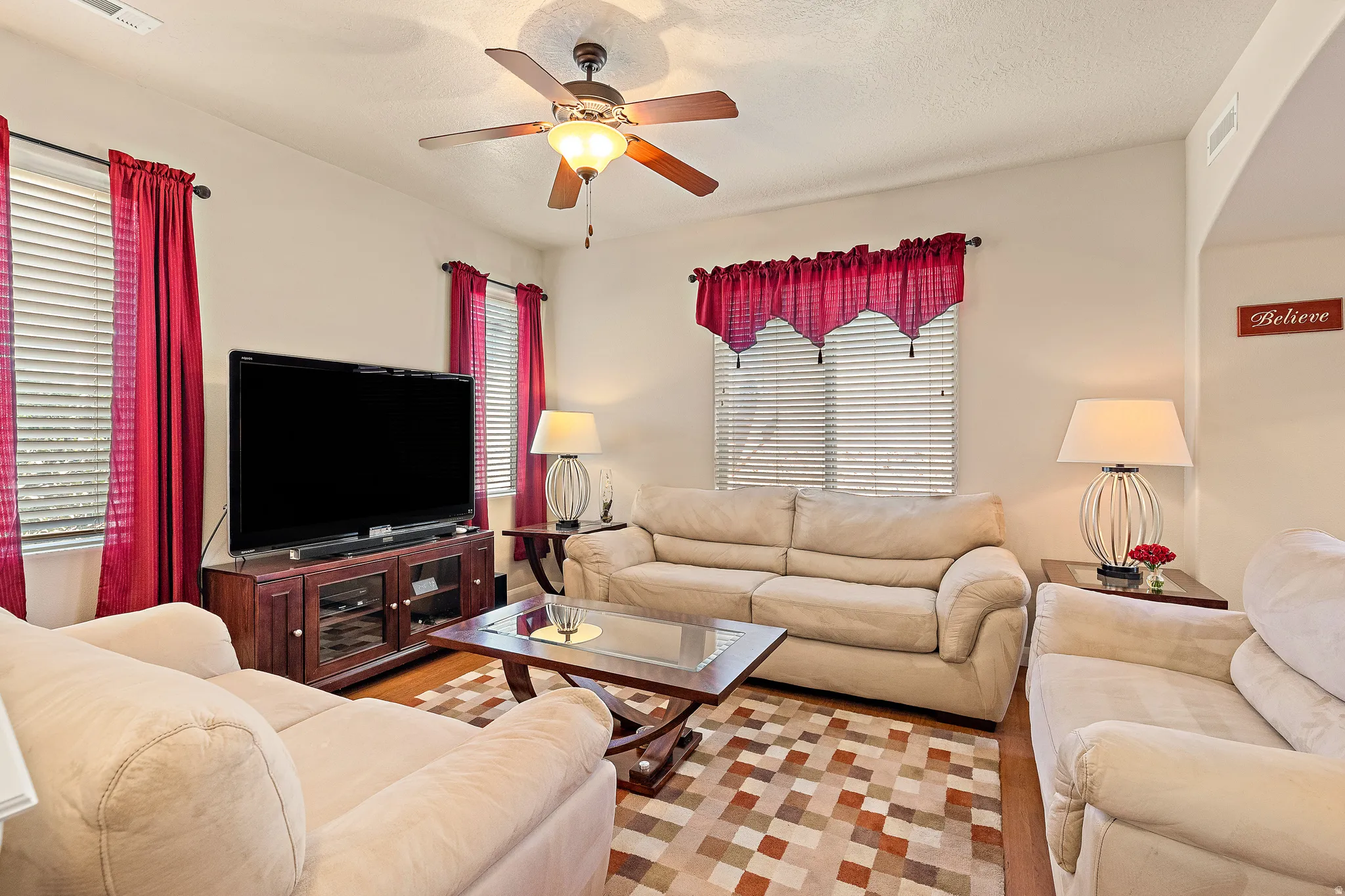 Living room featuring ceiling fan and a textured ceiling