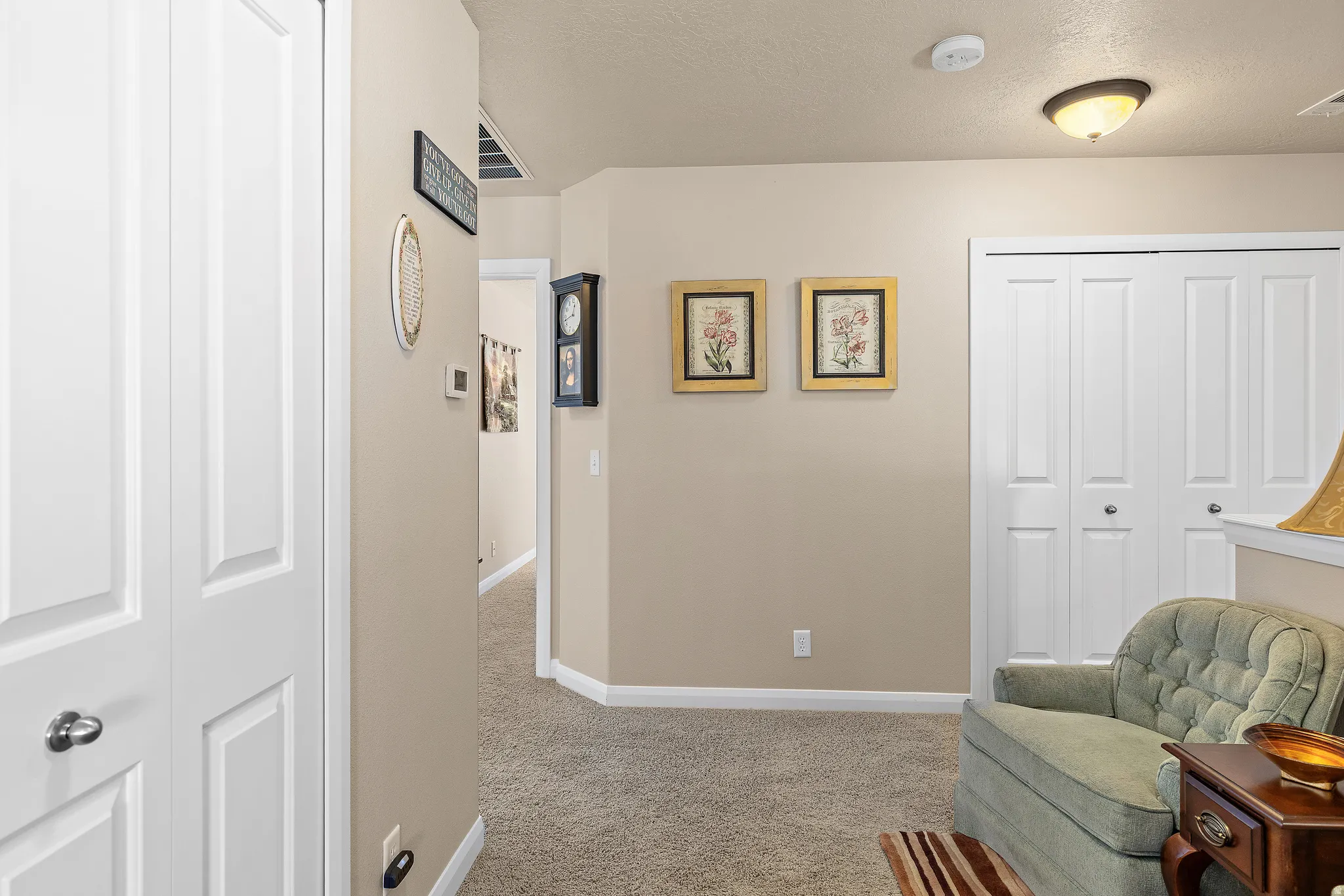 Living area with light carpet and a textured ceiling