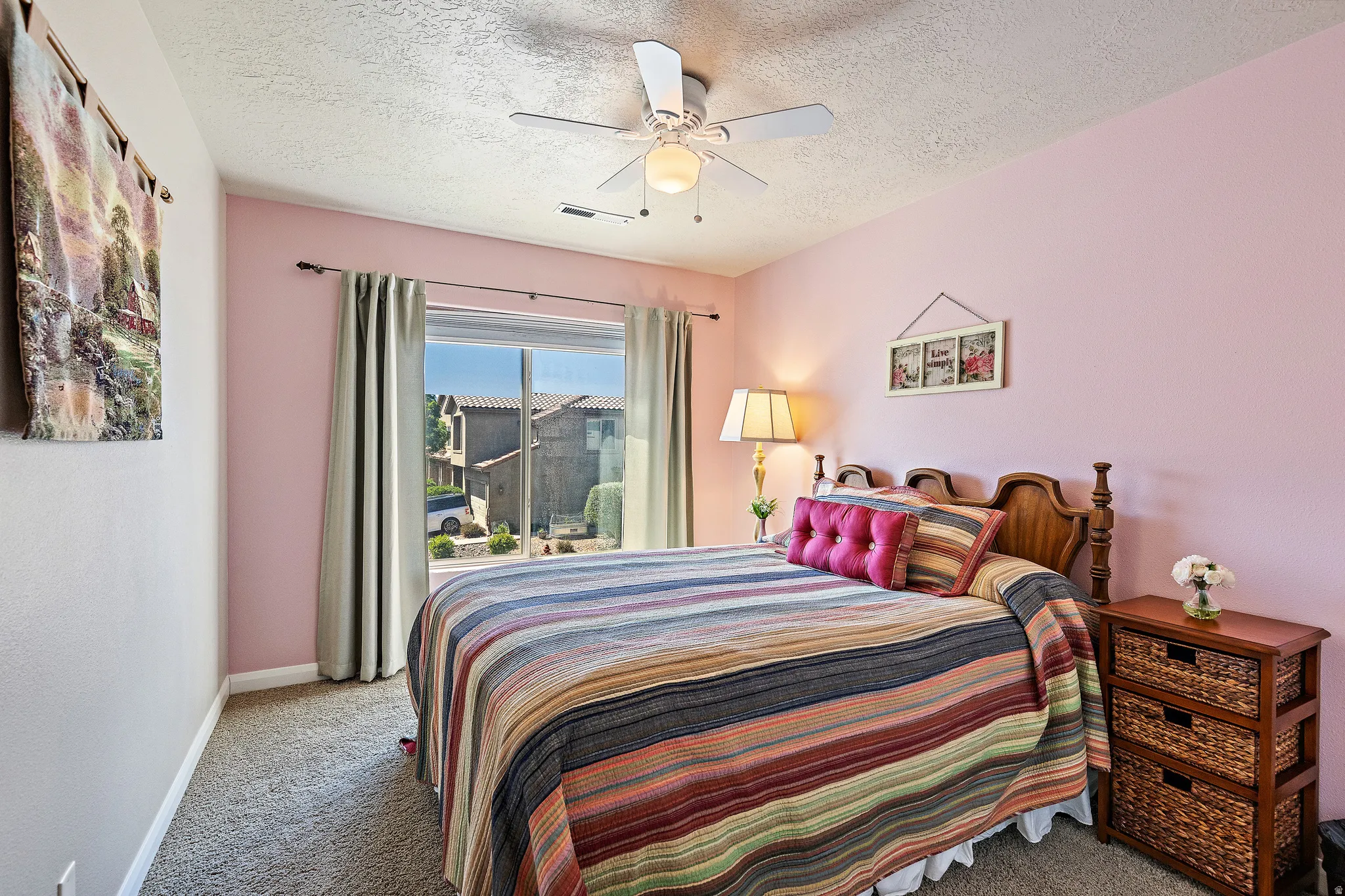 Bedroom with carpet flooring, a ceiling fan, and a textured ceiling