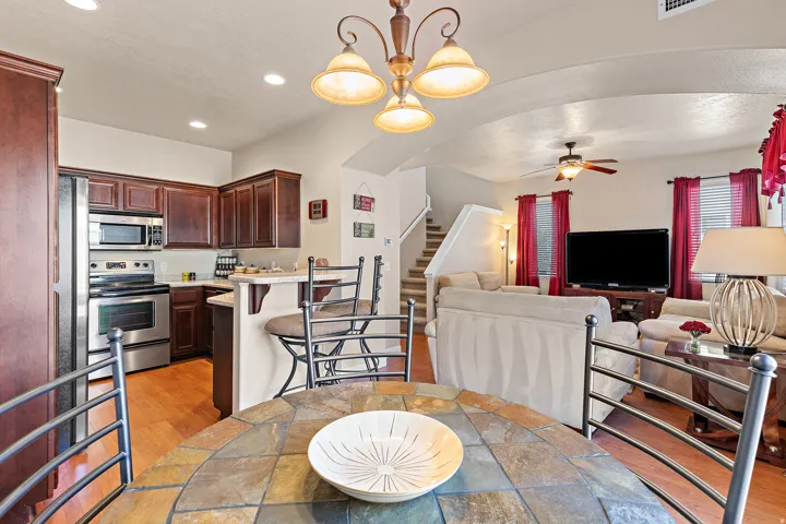 Dining space featuring hanging lights, light wood-style flooring, a ceiling fan, and arched walkways