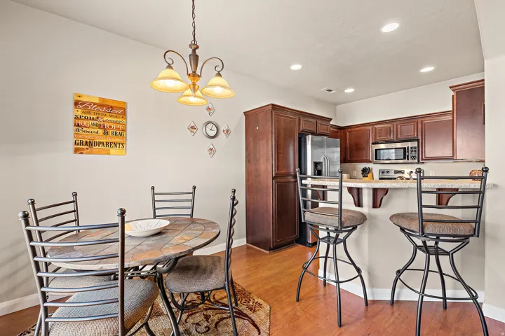 Kitchen with a breakfast bar, a peninsula, hanging lights, and light wood-type flooring