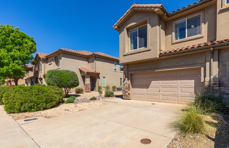 Mediterranean / spanish-style house with an attached garage, a tile roof, stucco siding, and concrete driveway