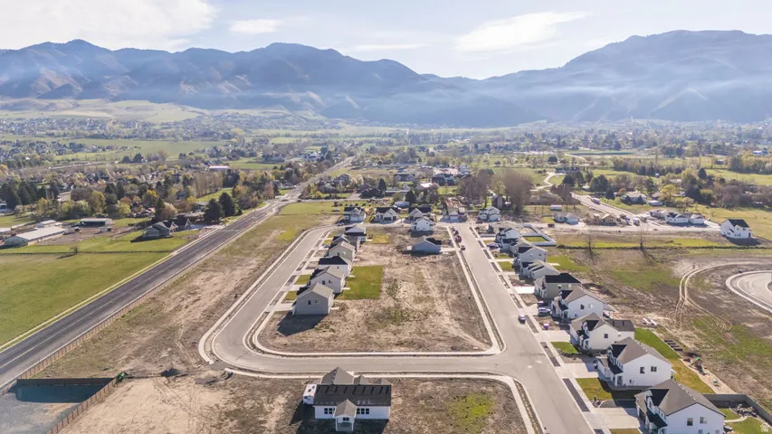 Aerial view of property's location featuring a mountain backdrop and nearby suburban area