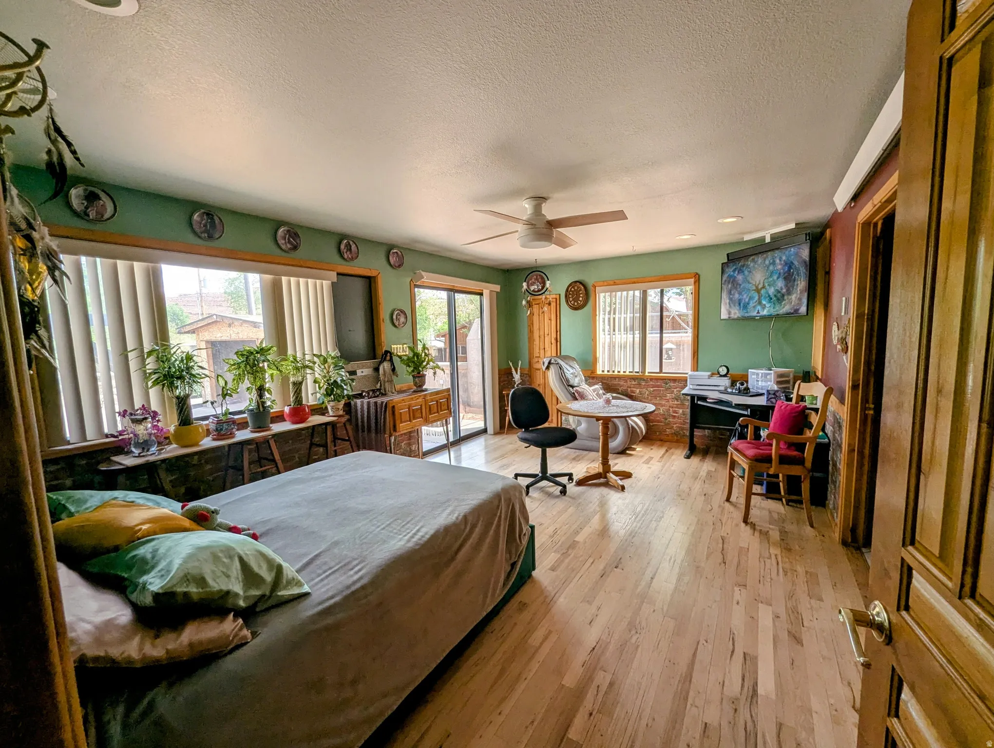 Bedroom with access to outside, hardwood / wood-style flooring, a textured ceiling, and a ceiling fan