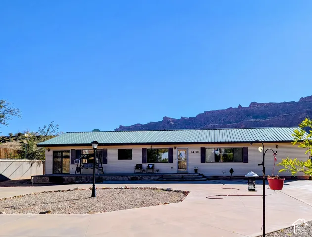 Single story home with a mountain view and a metal roof