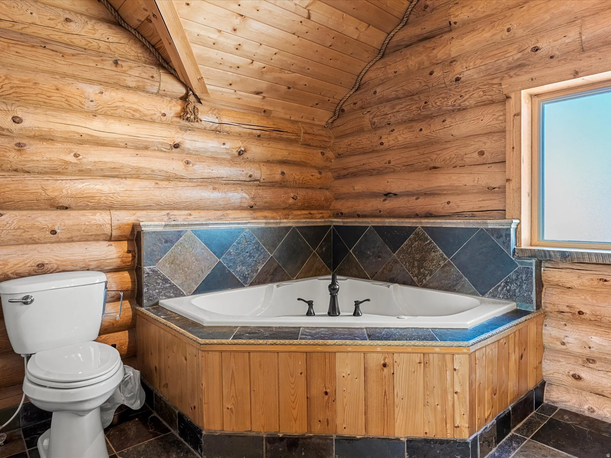 Full bath with a garden tub and rustic walls