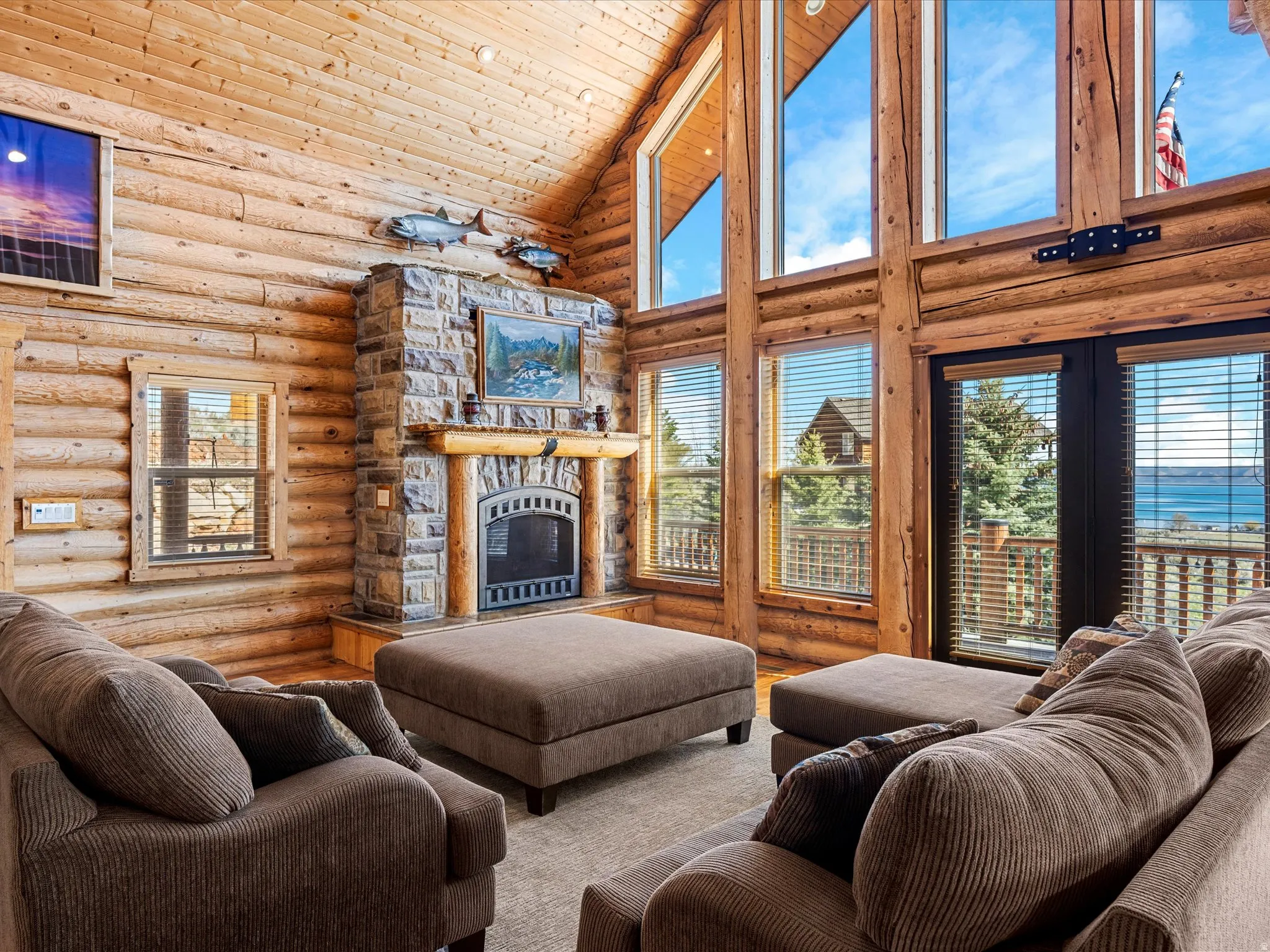 Living room featuring rustic walls, a fireplace, and a vaulted wood ceiling