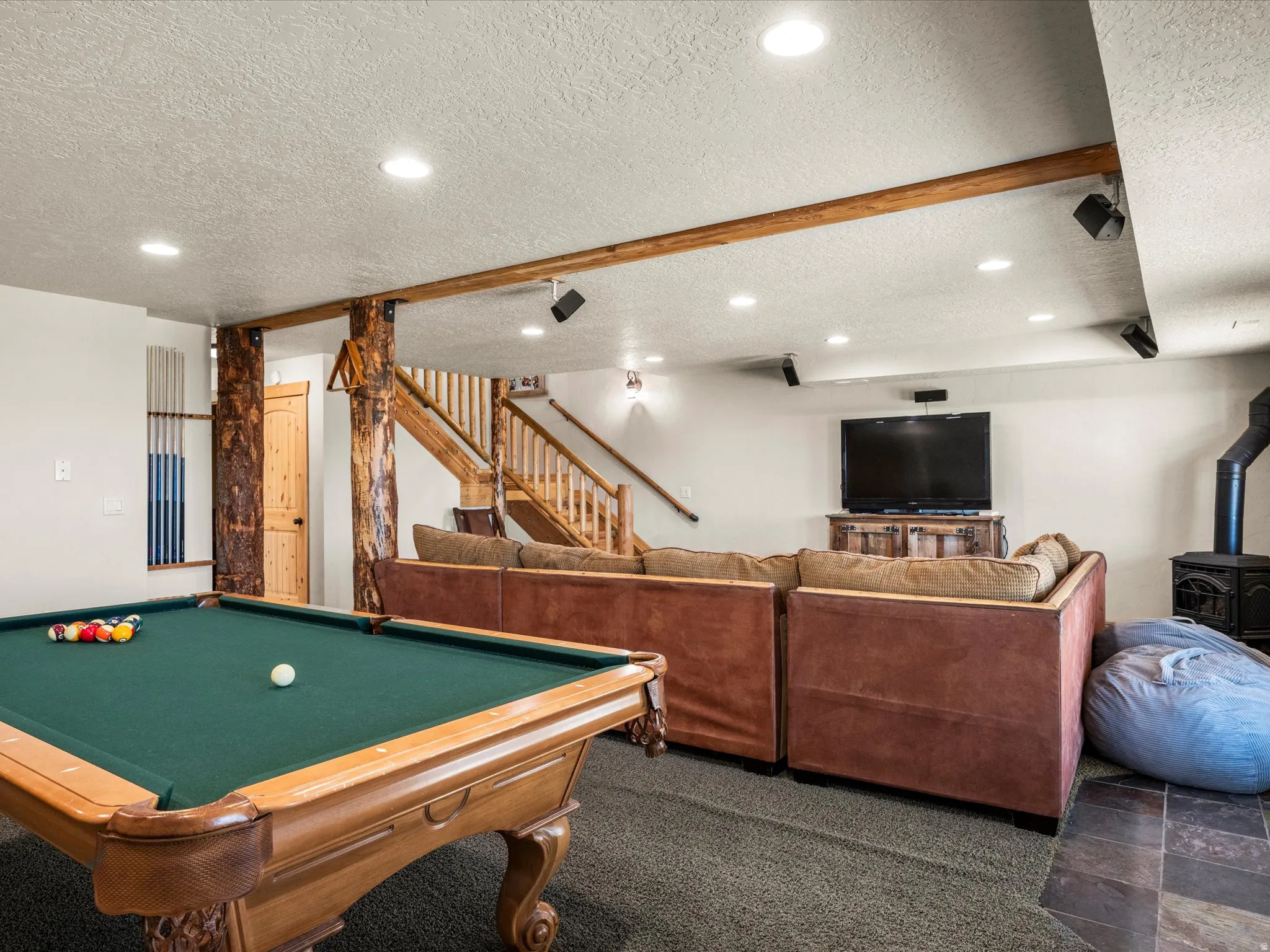Playroom with dark carpet, a wood stove, pool table, a textured ceiling, and recessed lighting