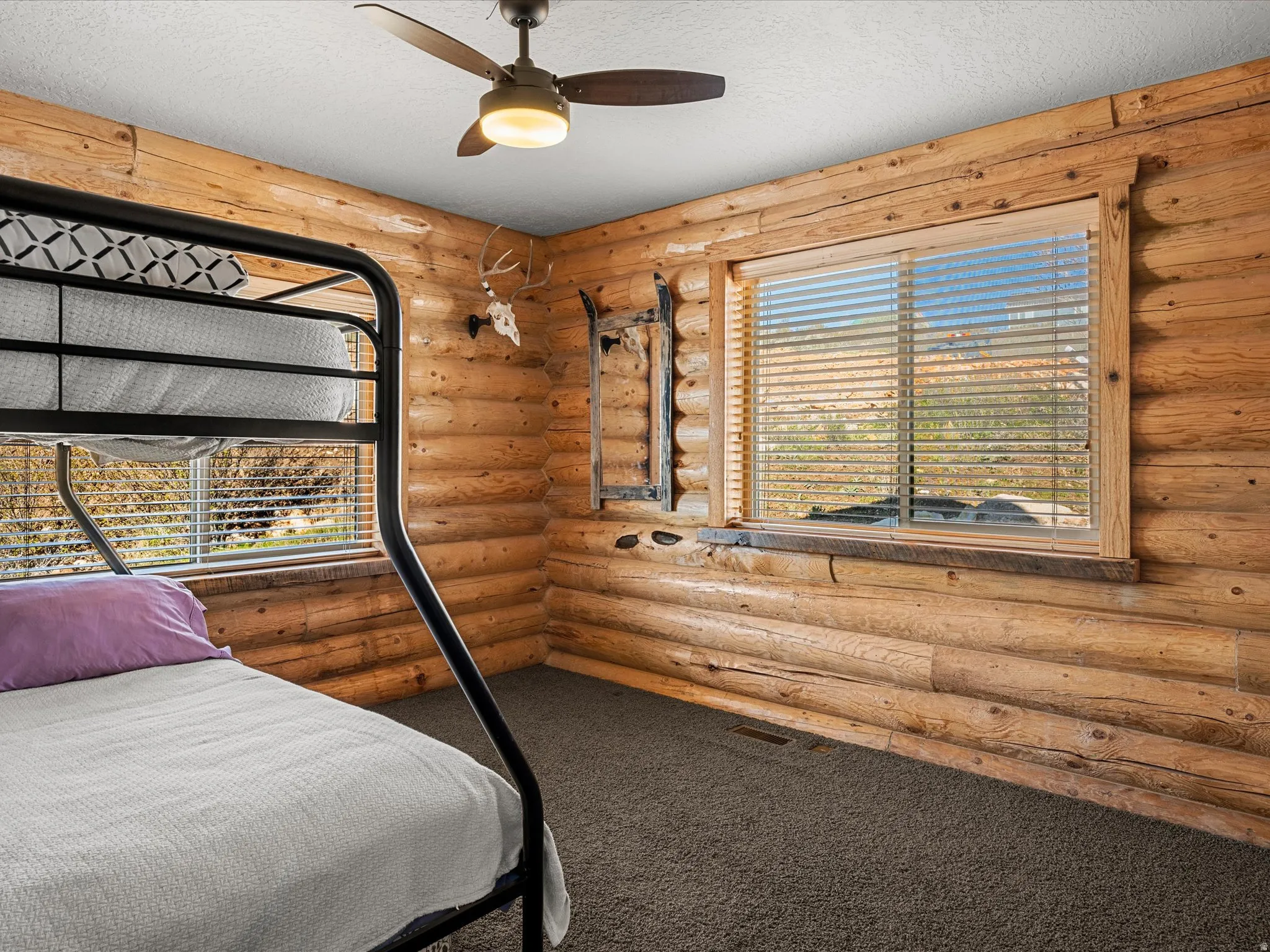 Carpeted bedroom featuring a ceiling fan and a textured ceiling