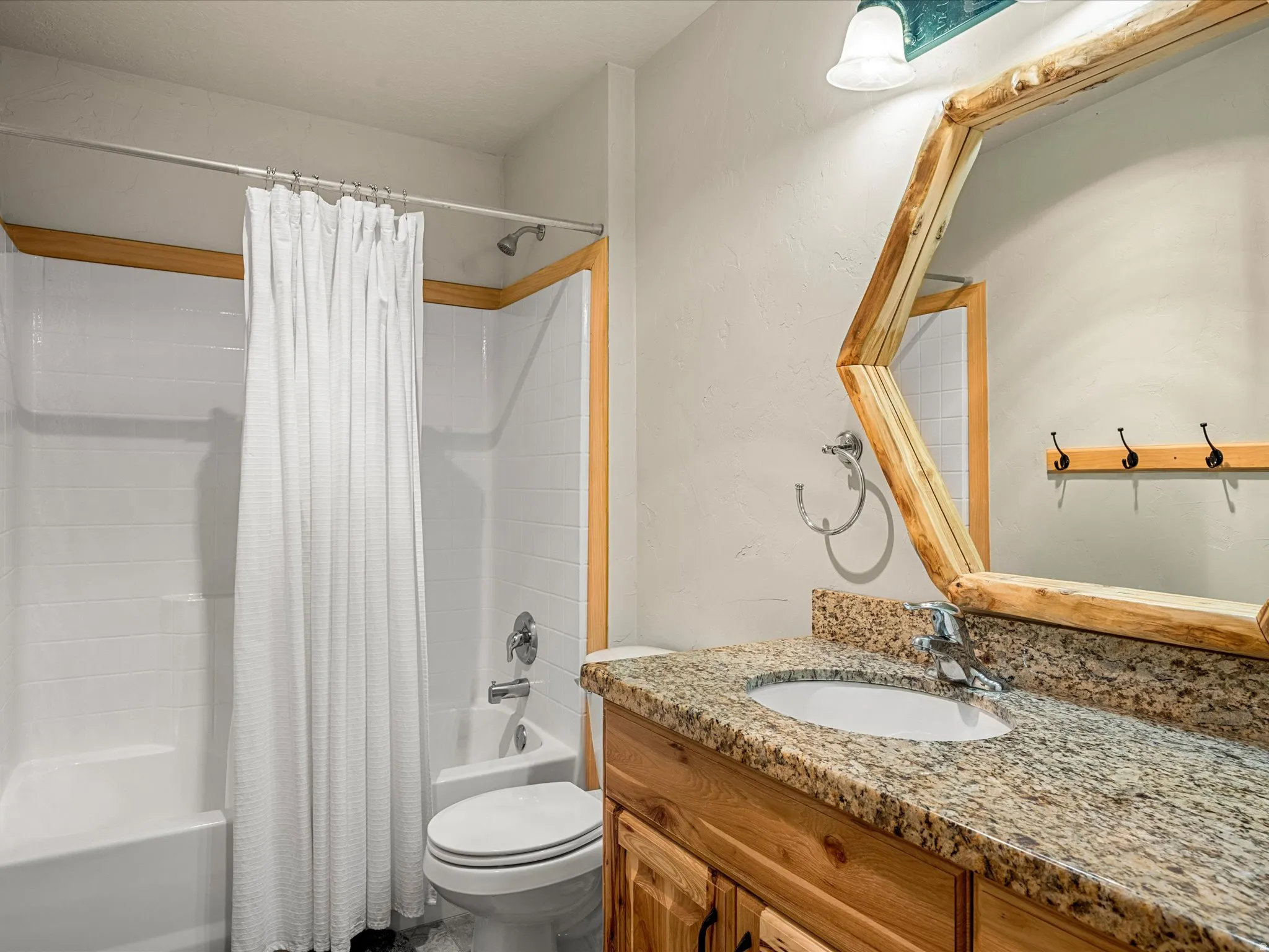 Bathroom featuring vanity and shower / bathtub combination with curtain