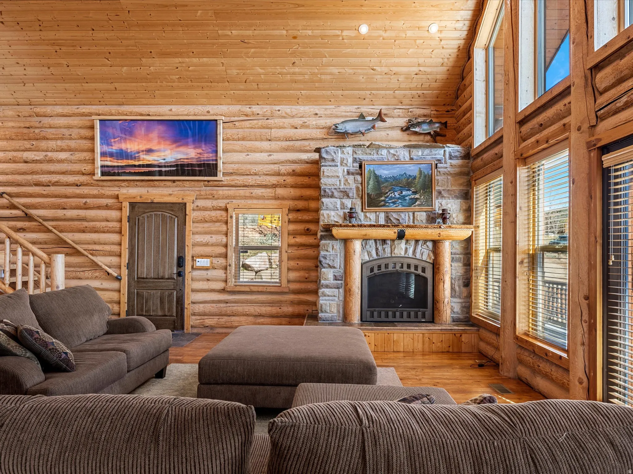 Living room featuring rustic walls, a fireplace, wood-type flooring, and a vaulted wood ceiling