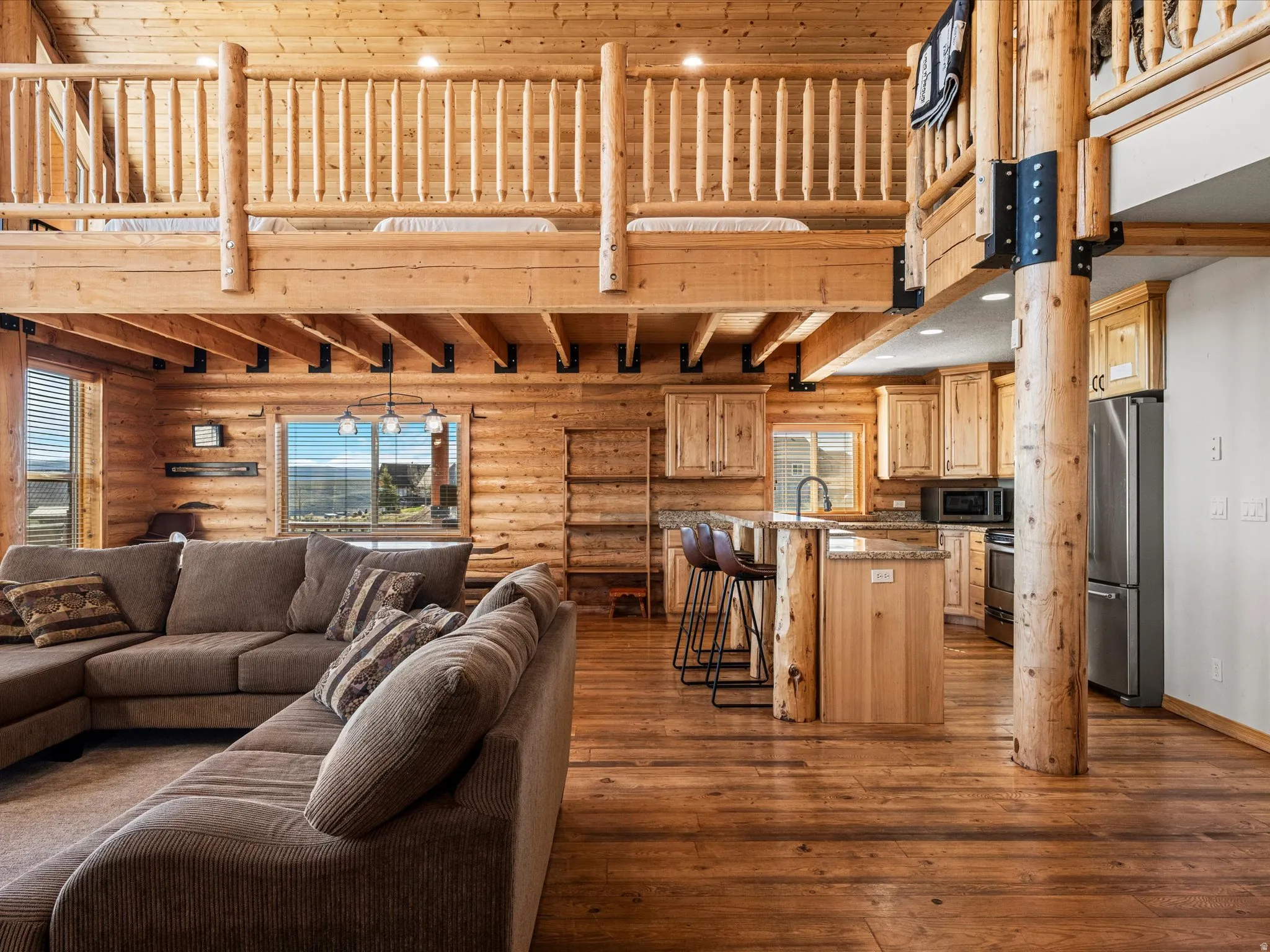 Living area featuring dark wood-style flooring, a high wooden ceiling, and rustic walls