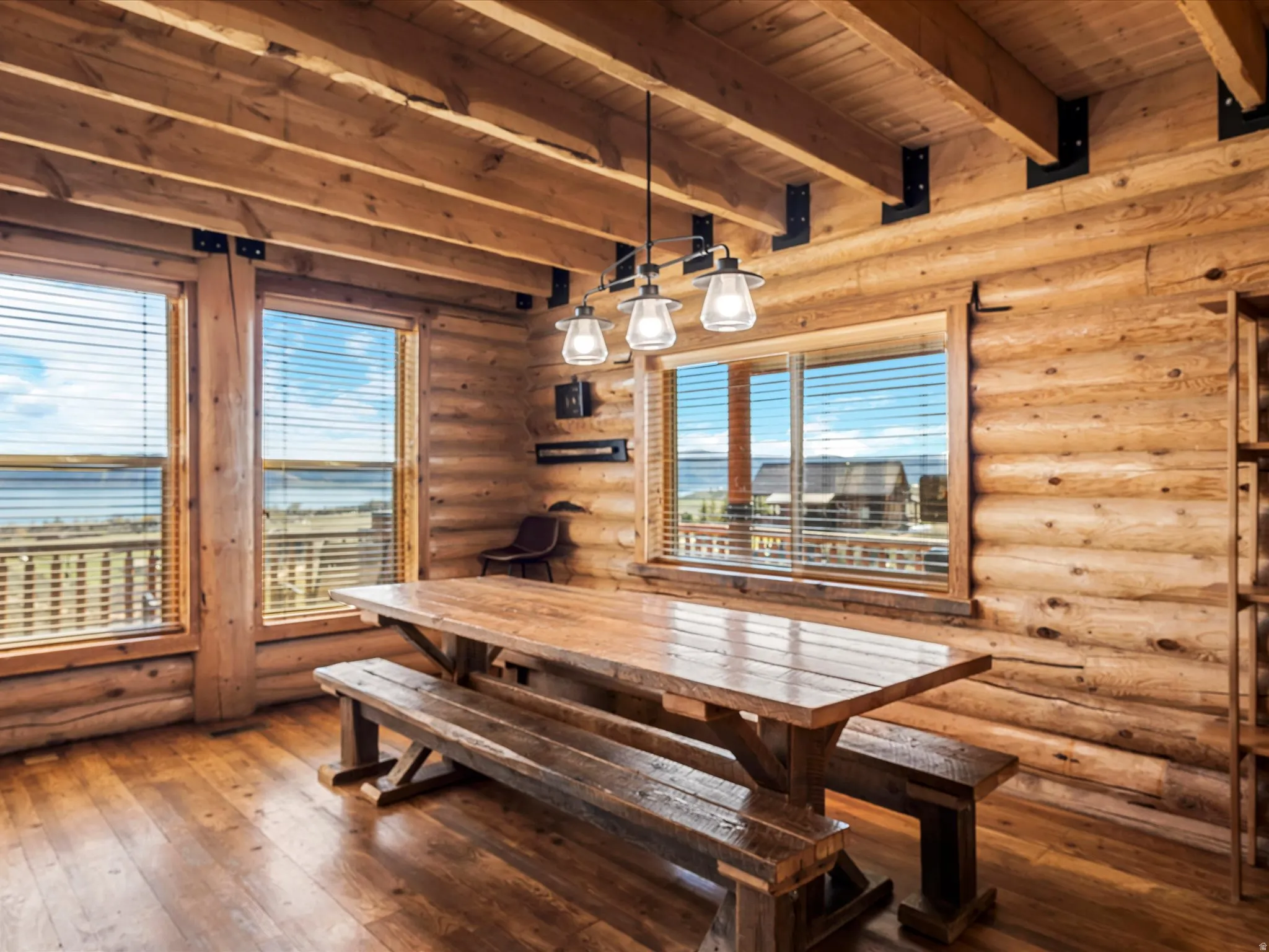 Dining space featuring rustic walls, dark wood-style flooring, and a wooden ceiling with exposed beams