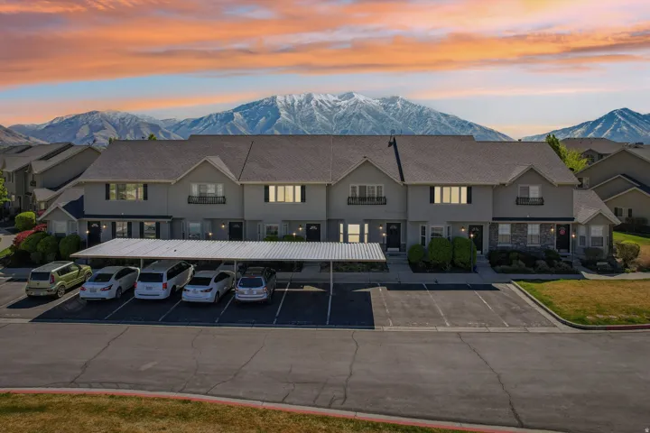 Property at dusk featuring a mountain view and covered and uncovered parking