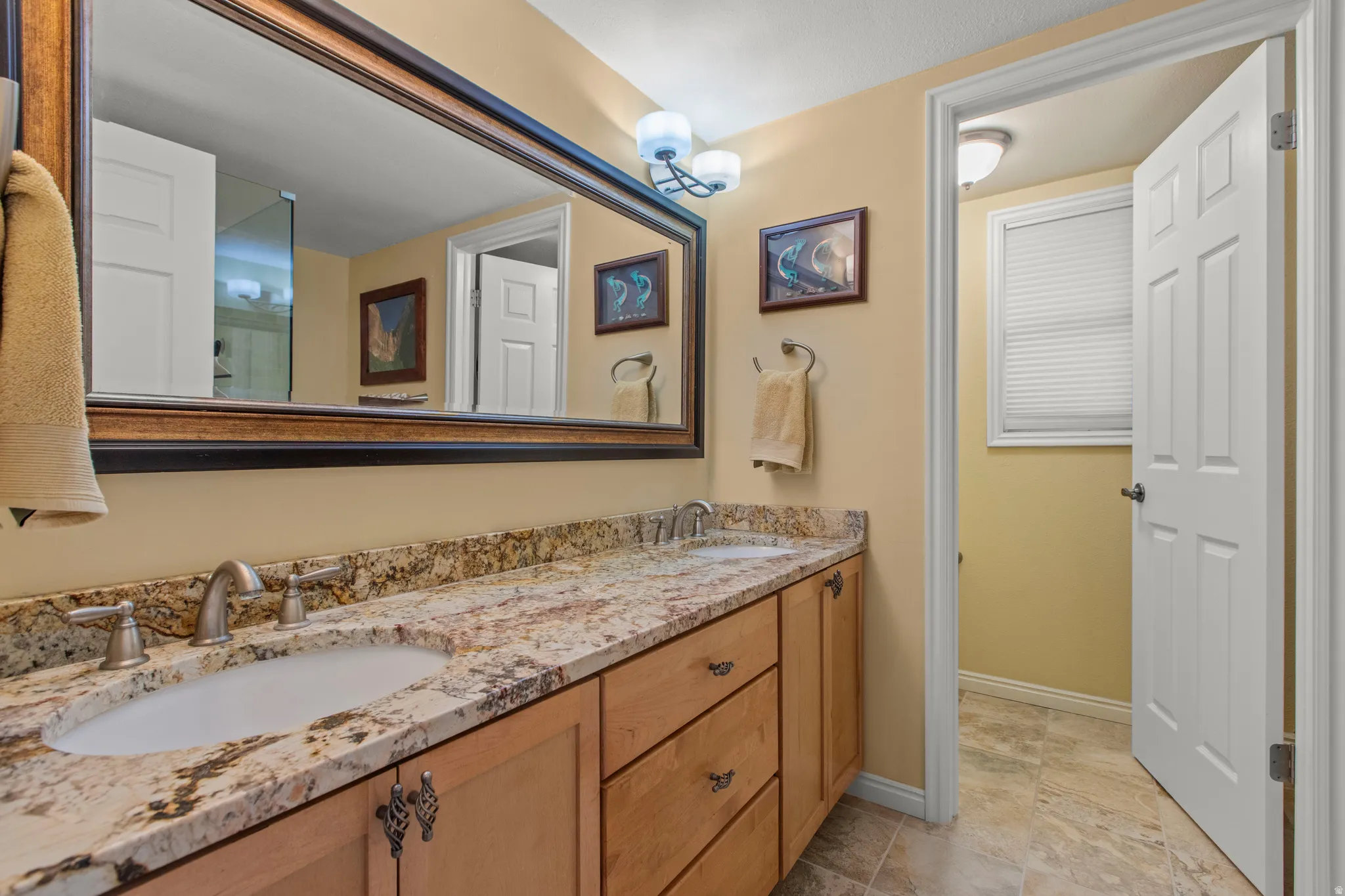 Full bathroom with double vanity and baseboards