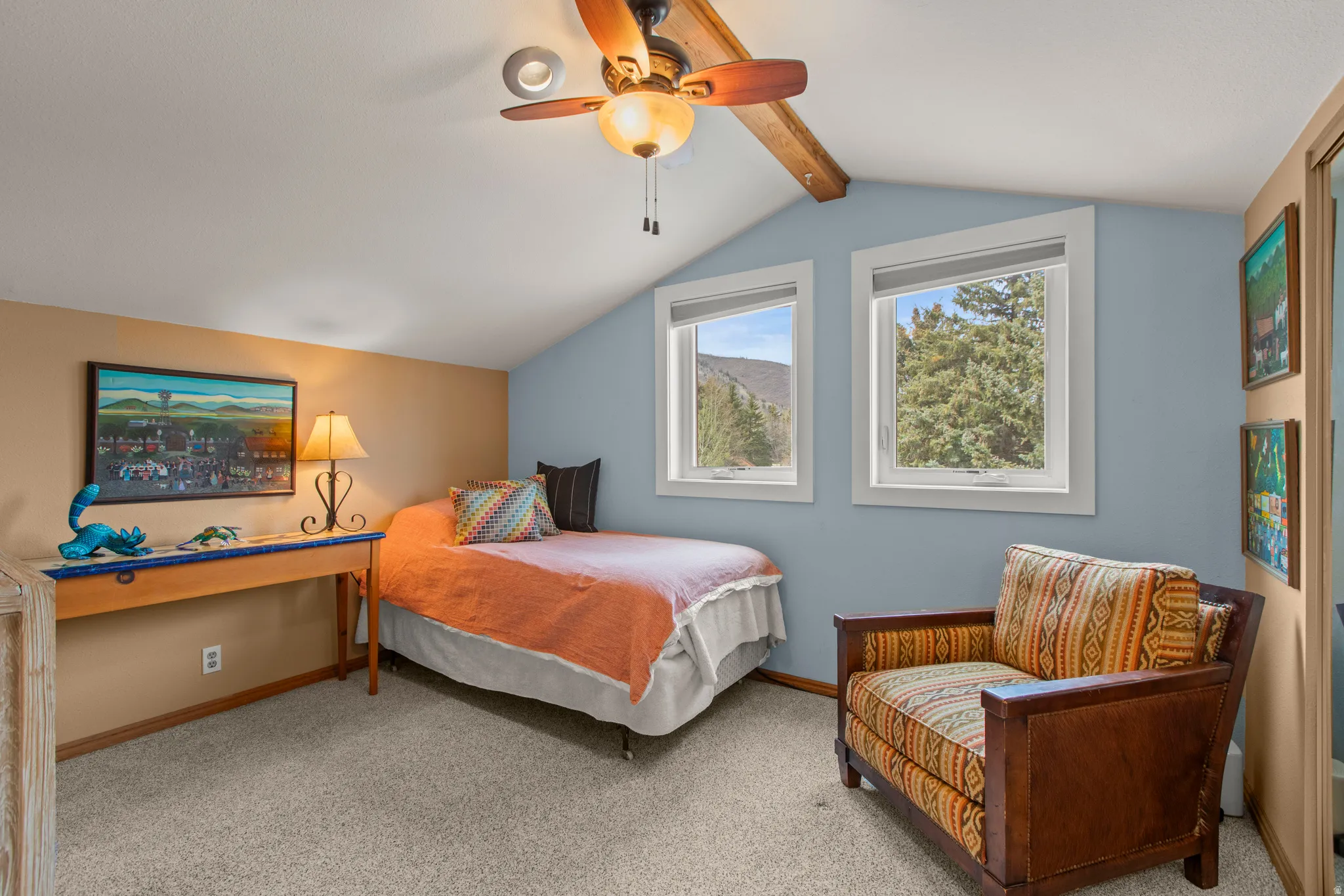 Carpeted bedroom with ceiling fan and beamed ceiling