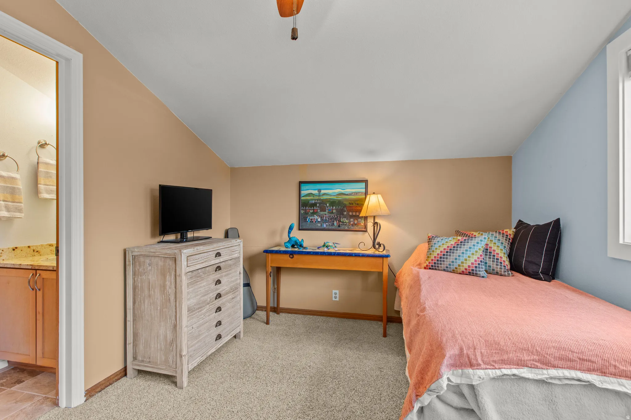 Bedroom featuring vaulted ceiling, carpet floors, a ceiling fan, and ensuite bathroom