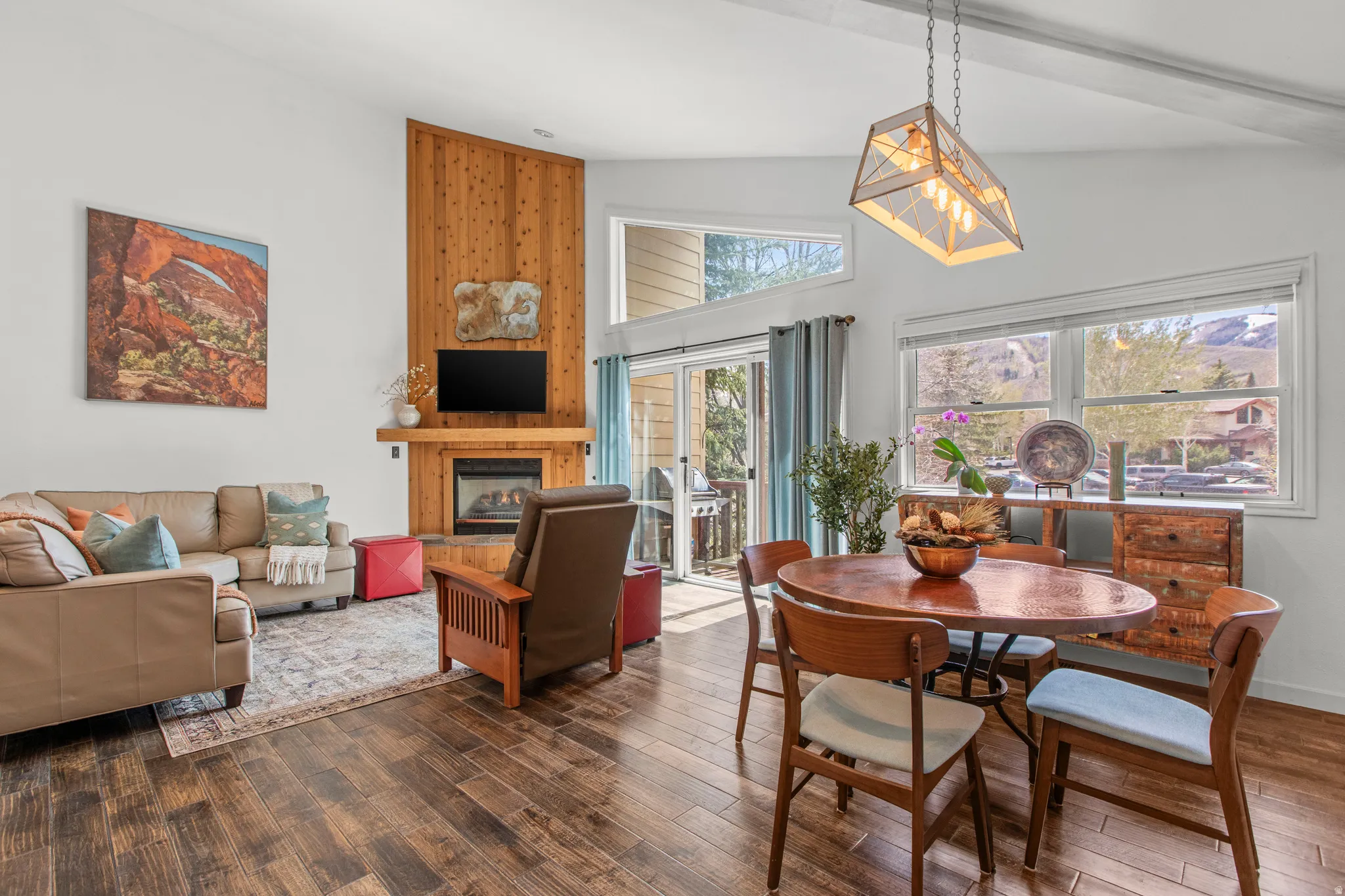Dining space featuring dark wood-type flooring, a high ceiling, and a large fireplace