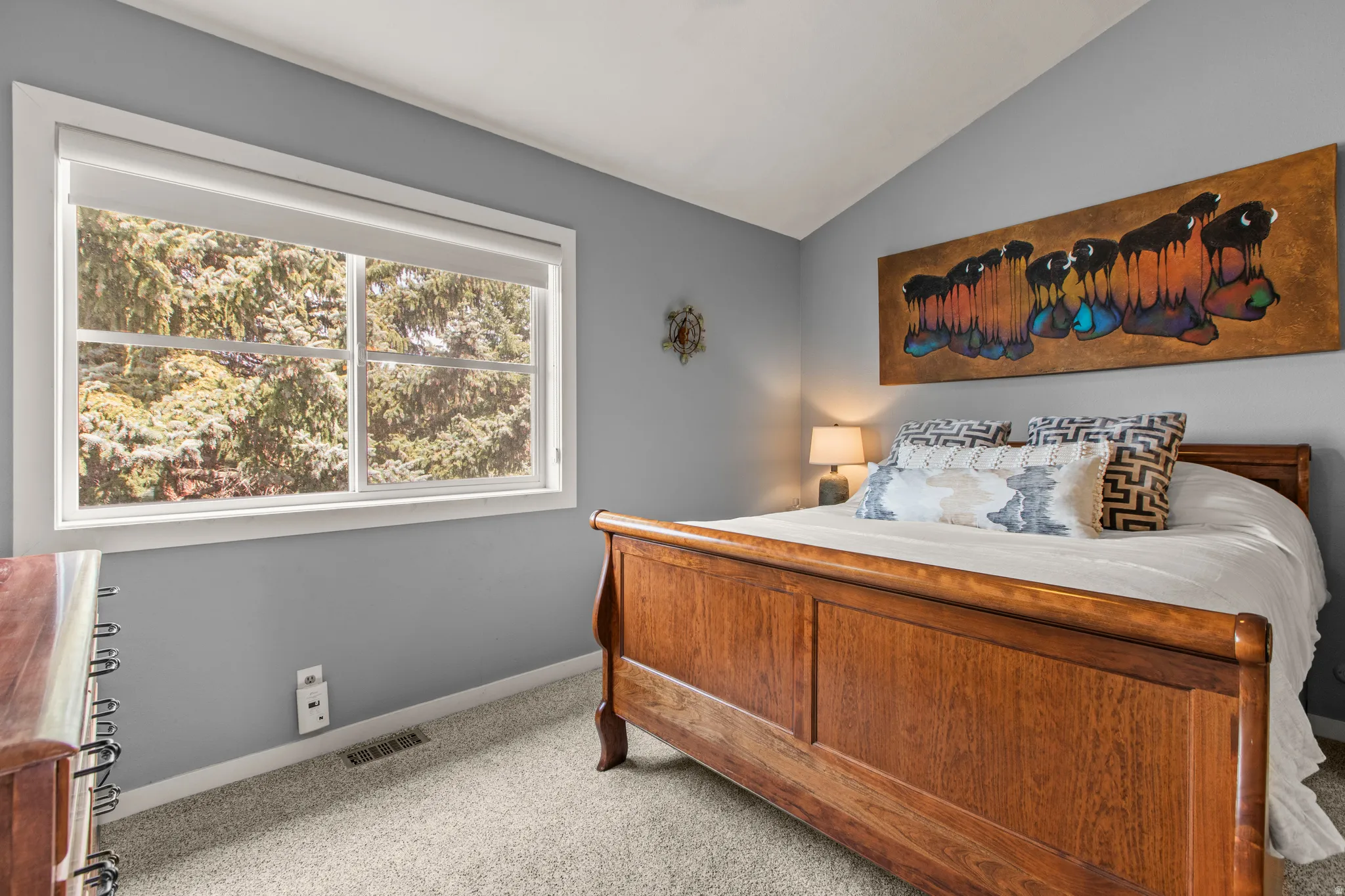 Bedroom with vaulted ceiling and light carpet